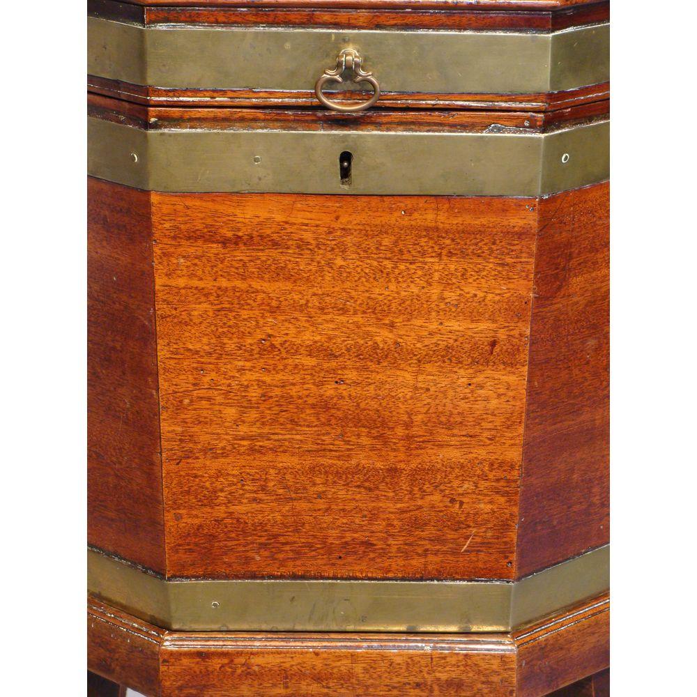 Ein Weinkühler aus Mahagoni mit Messingbeschlägen aus dem späten 18. Jahrhundert, auf einem abnehmbaren Ständer mit vier sich verjüngenden Beinen, die in Messingkappen und Rollen enden. 
Der Innenraum hat die ursprüngliche Bleiverkleidung und den
