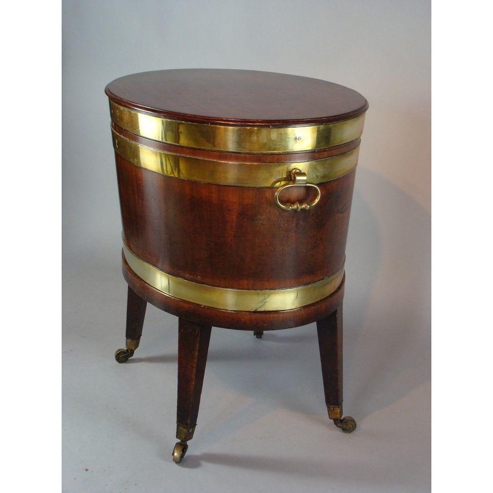 An oval mahogany wine cooler, George III period, circa 1790.

With excellent, unrestored, deep, rich color and patination, and original solid-brass carrying handles to either side.

This smart Georgian wine cooler (cellaret or cellarette) retains