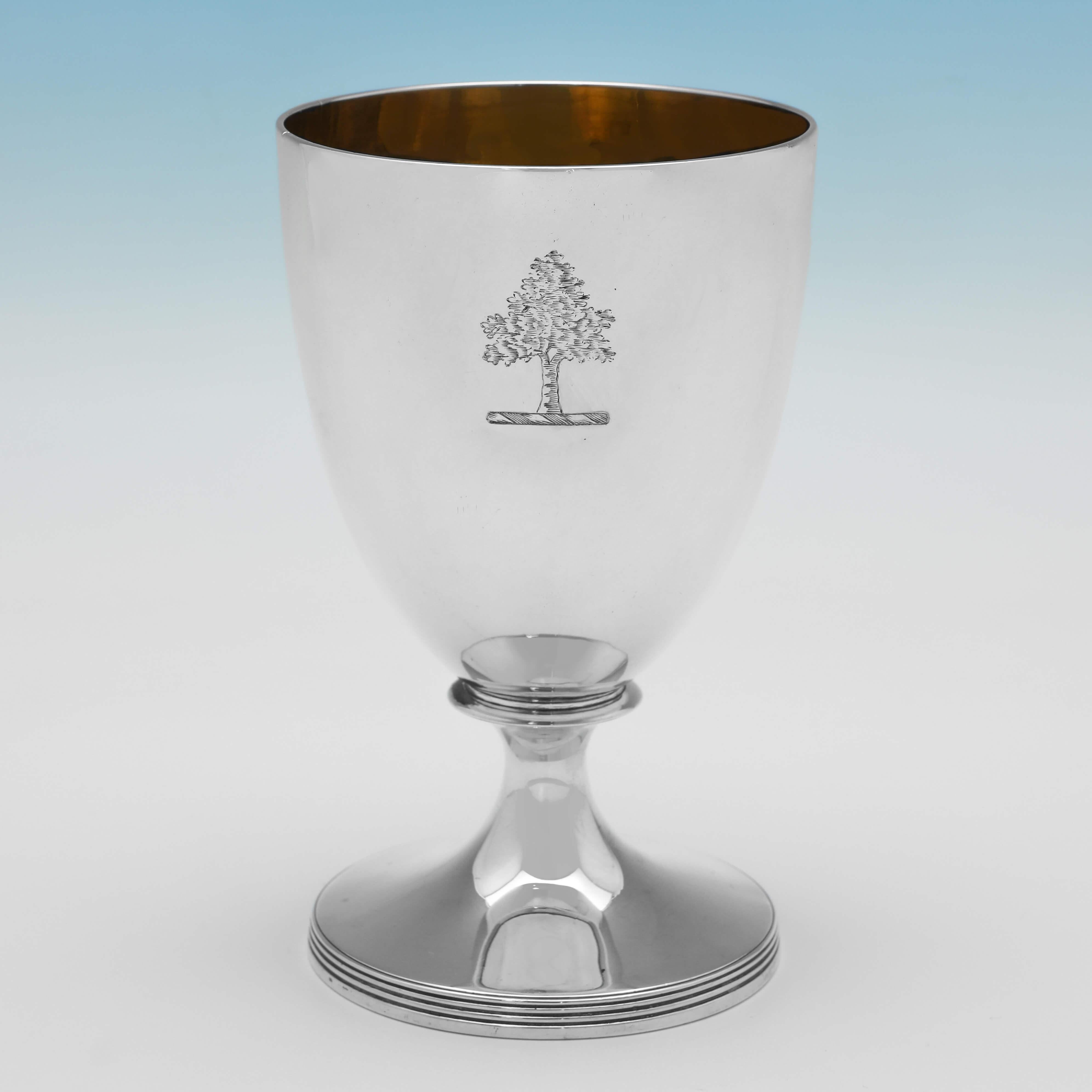 Hallmarked in London in 1802 by John Emes, this handsome pair of George III period, Antique Sterling Silver Goblets, are elegant in design, featuring engraved crests to each, reed detailing and gilt interiors. 

Each goblet measures 6