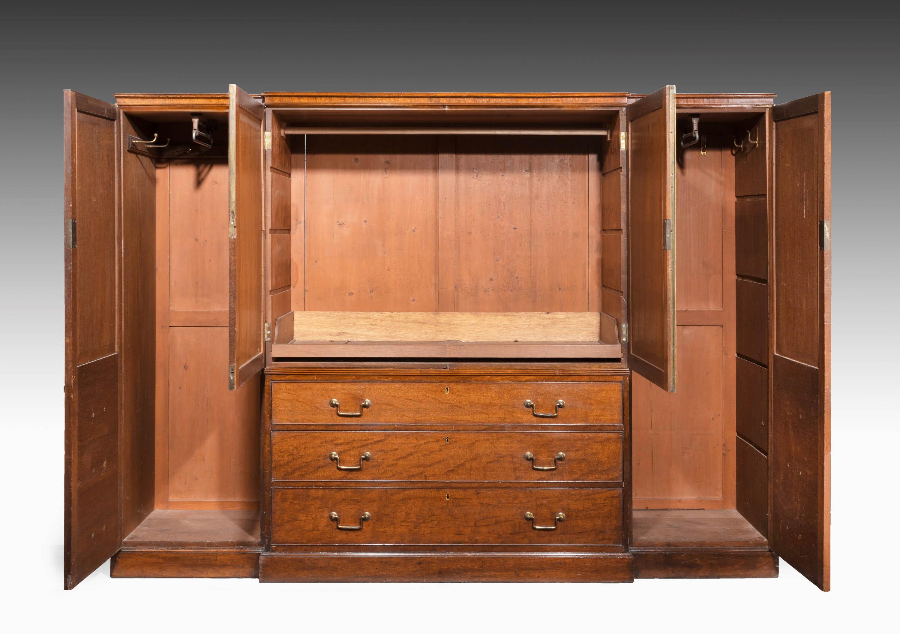 A quite exceptional George III period plum pudding mahogany breakfront wardrobe. With quite exceptional figured timbers matching book leaf left and right-hand side. Square section period handles retaining the original gilding. Unusually tight