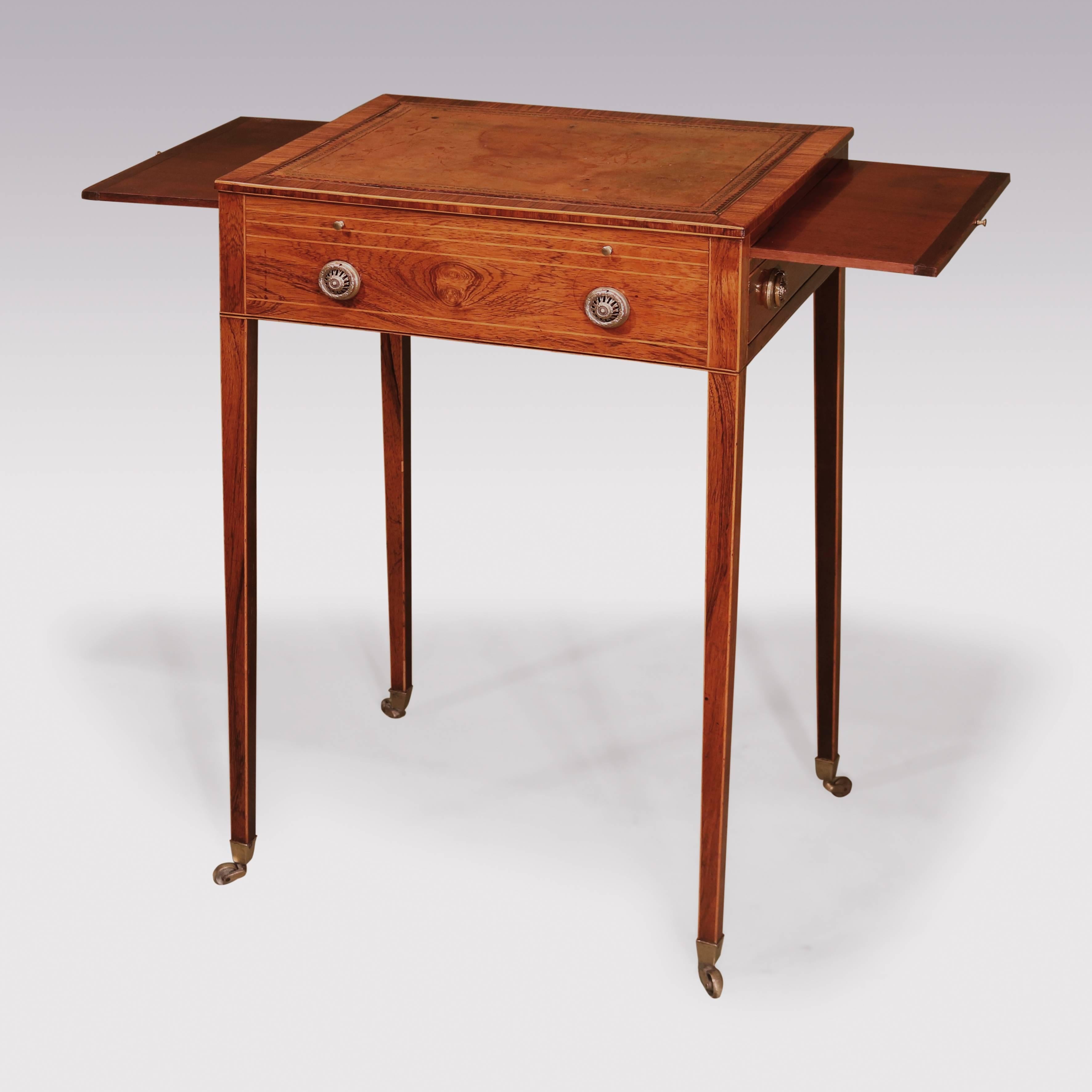 A George III period rosewood occasional table, boxwood strung throughout, having tulipwood crossbanded leather top, above drawer and brushing slides to frieze, supported on square tapering legs, ending on original brass castors.