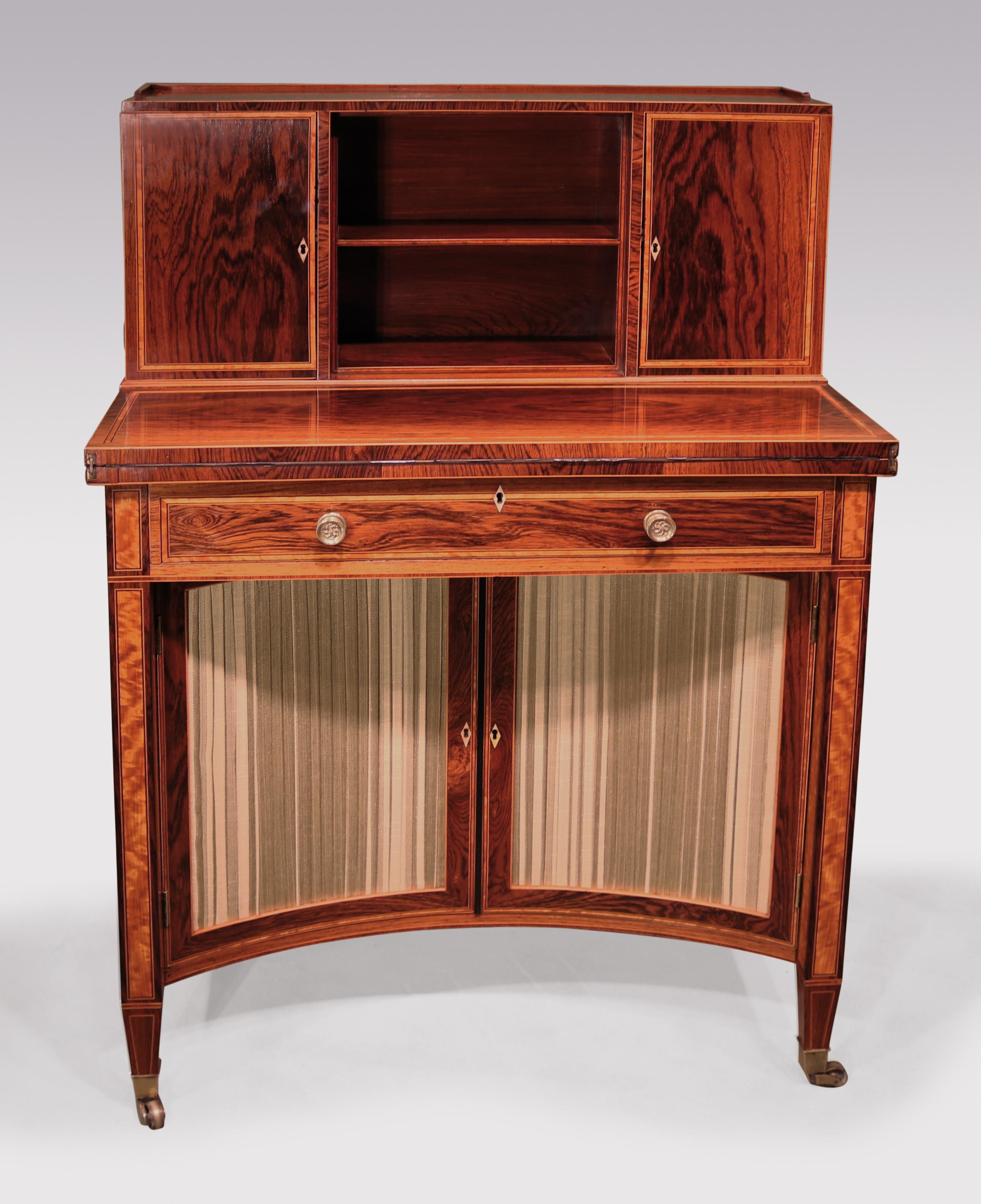 A fine George III period rosewood veneered concave door cabinet, boxwood and ebony strung & satinwood banded throughout, having galleried upper section with doors enclosing drawers & slides. The piece, with fold-over writing surface above frieze