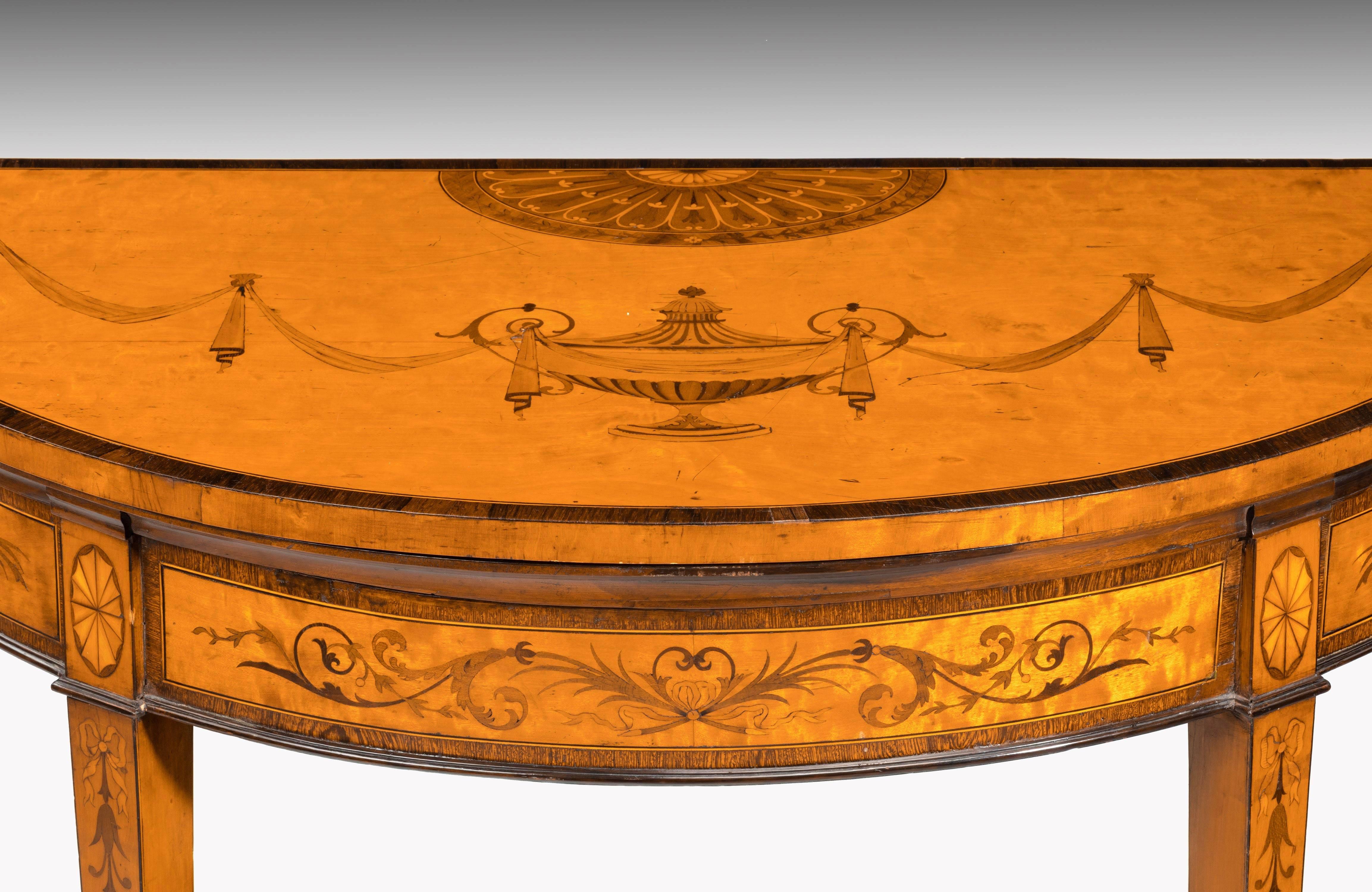 A particularly fine, George III period, satinwood demilune card table with very finely executed marquetry and parquetry inlays of exotic timbers. Tapering supports ending in box shoes.