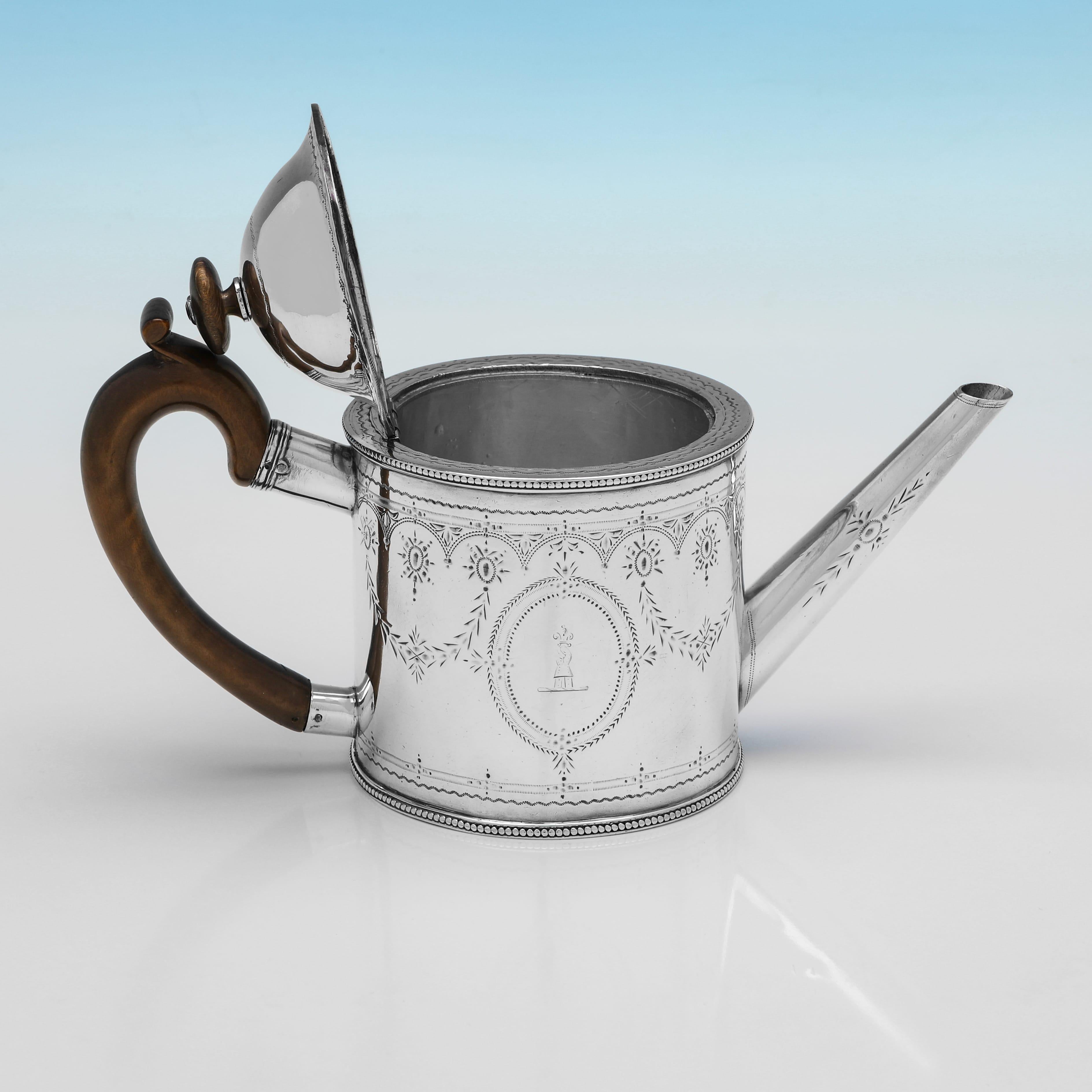 Marcada en Londres en 1774 por Edward Cooper, esta atractiva tetera antigua de plata de ley de Jorge III tiene forma de 