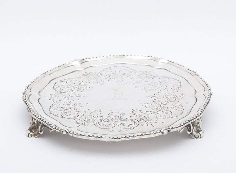 George III, sterling silver footed salver/tray, London, year-hallmarked for 1773, Robert Redrick - maker. Etched design, having a central armorial of a griffin. Scalloped, beaded border. Measures 6 inches diameter x 3/4 inches high. Weighs 6.105