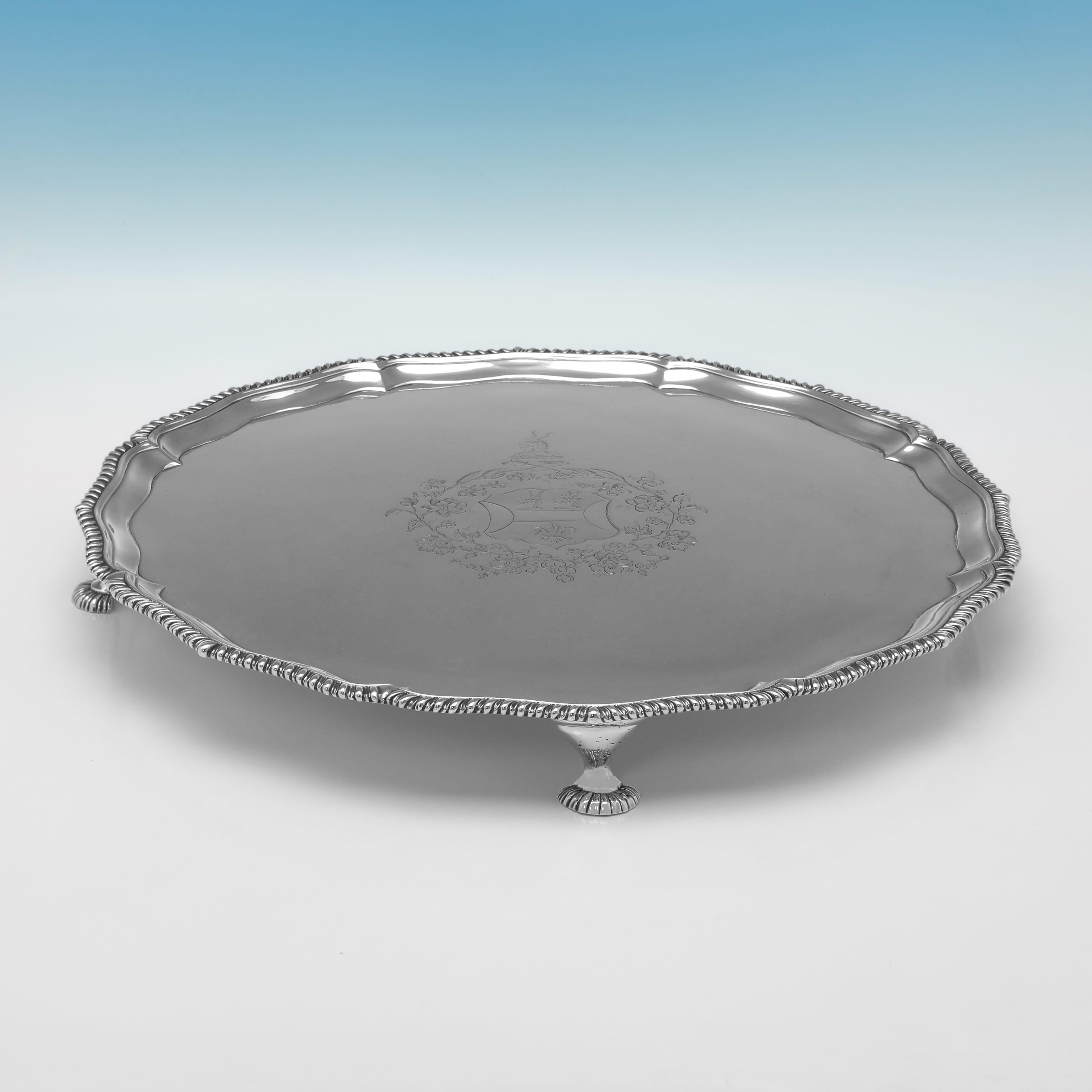 Poinçonné à Londres en 1771 par Ebenezer Coates, ce beau saloir ancien en argent sterling d'époque George III repose sur quatre pieds évasés et présente une bordure à godrons, ainsi qu'un blason et un écusson gravés dans le cartouche central. Le