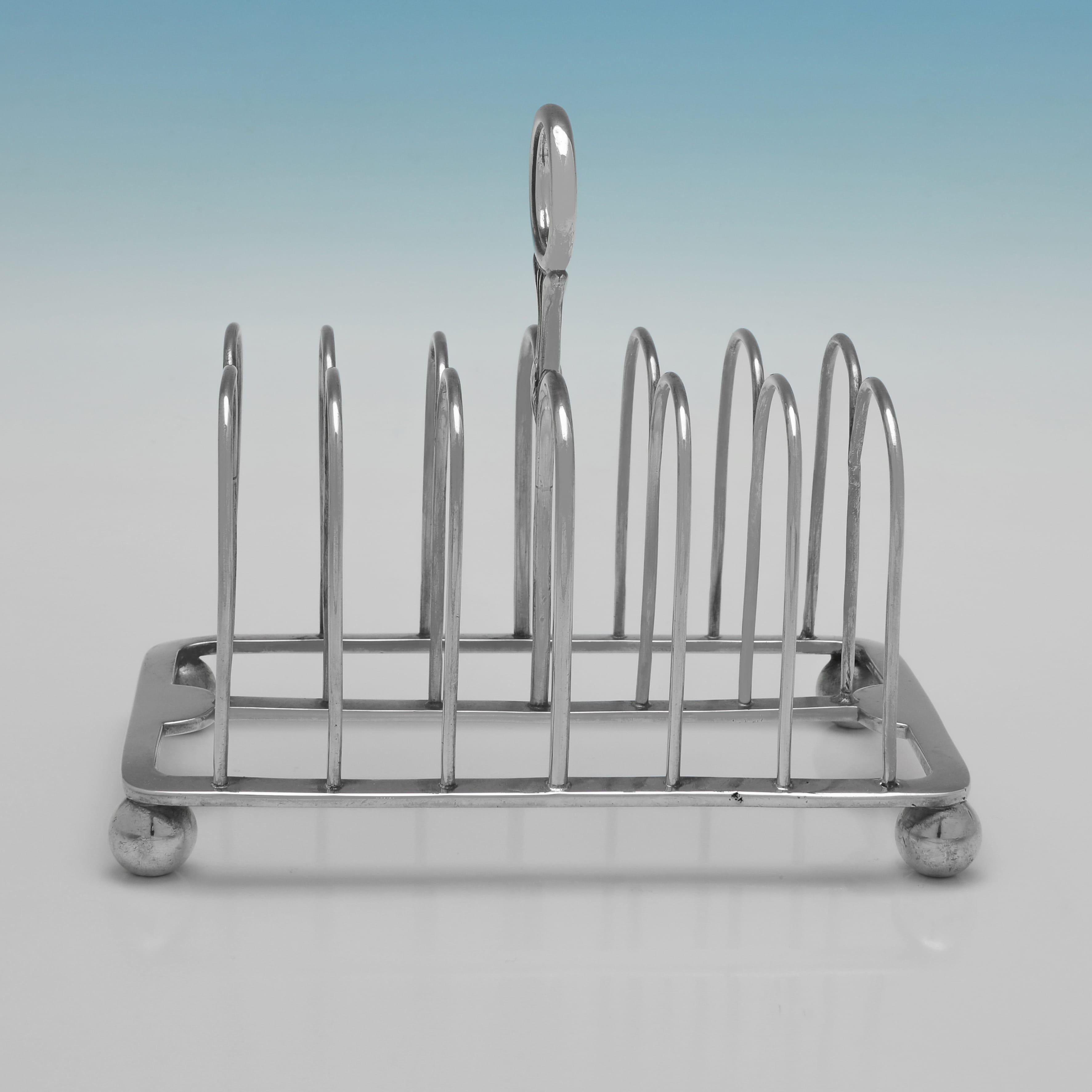 Poinçonné à Londres en 1829 par Samuel Whitford II, ce magnifique porte-tartine en argent sterling d'époque George IV repose sur 4 pieds à rotule et peut contenir 6 toasts. La grille mesure 14 cm de haut, 16 cm de large, 10 cm de profondeur et pèse