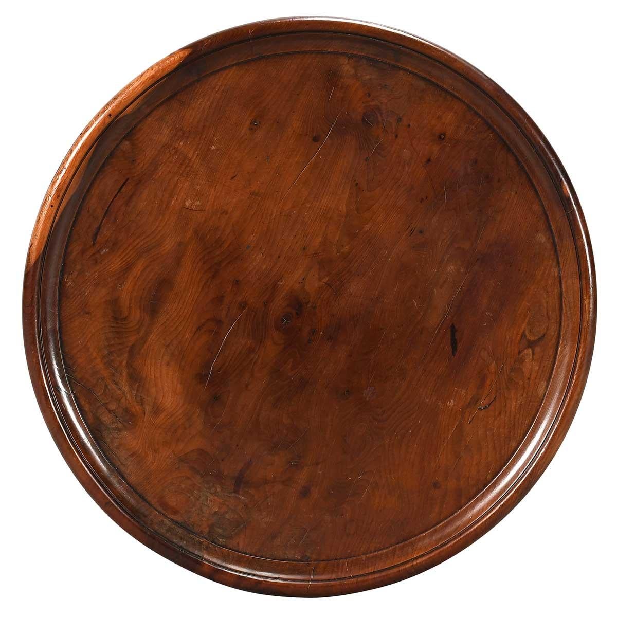 Une table de cricket fine et inhabituelle en bois d'if massif. Le plateau circulaire a un bord bombé. Les pieds sont habilement tournés et rejoints par des brancards également tournés qui sont surmontés d'une étagère de forme distinctive.