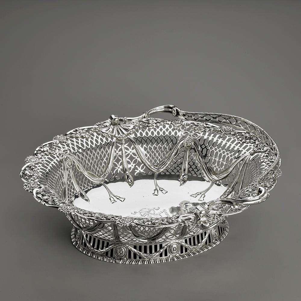 A beautiful antique Georgian solid silver basket with an elegant pierced pattern and a cast floral border. This beautiful basket stands on a flared beaded foot pierced with arched vertical pails. The main body is decorated with beaded bands and