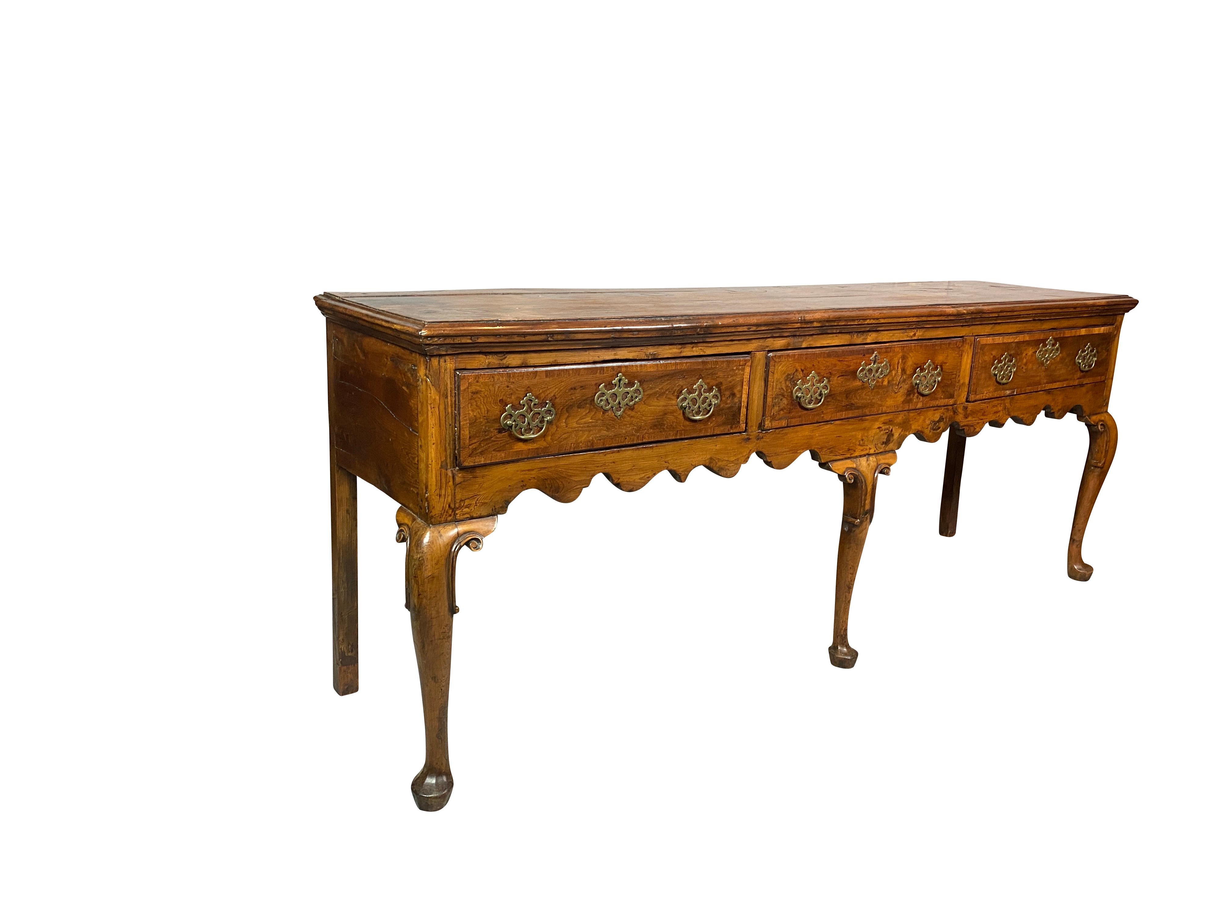 Rectangular top with beautiful rich color, molded edge over three drawers with cross banded edges, brass handles, raised on cabriole legs with scroll decoration at top of legs, ending on pad feet. Purchased in London in the 1970s.