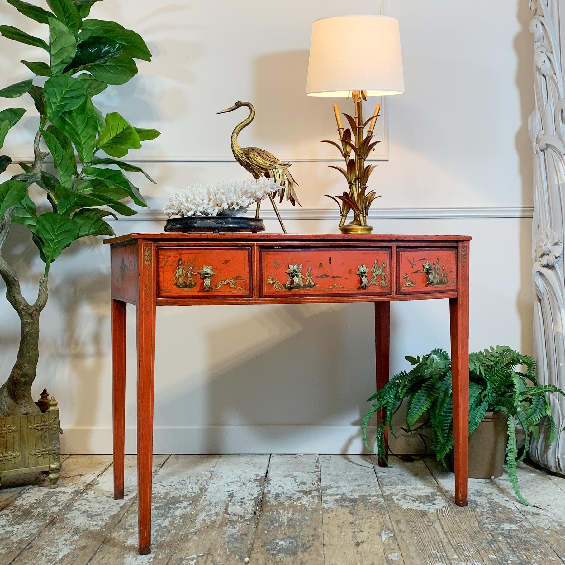 An outstanding bow fronted George III writing desk/side table, red jappaned with applied chinoiserie scenes.

This stunning desk sits on tapering square legs and has three fitted drawers, the drawer handles are later, one of the handles has a