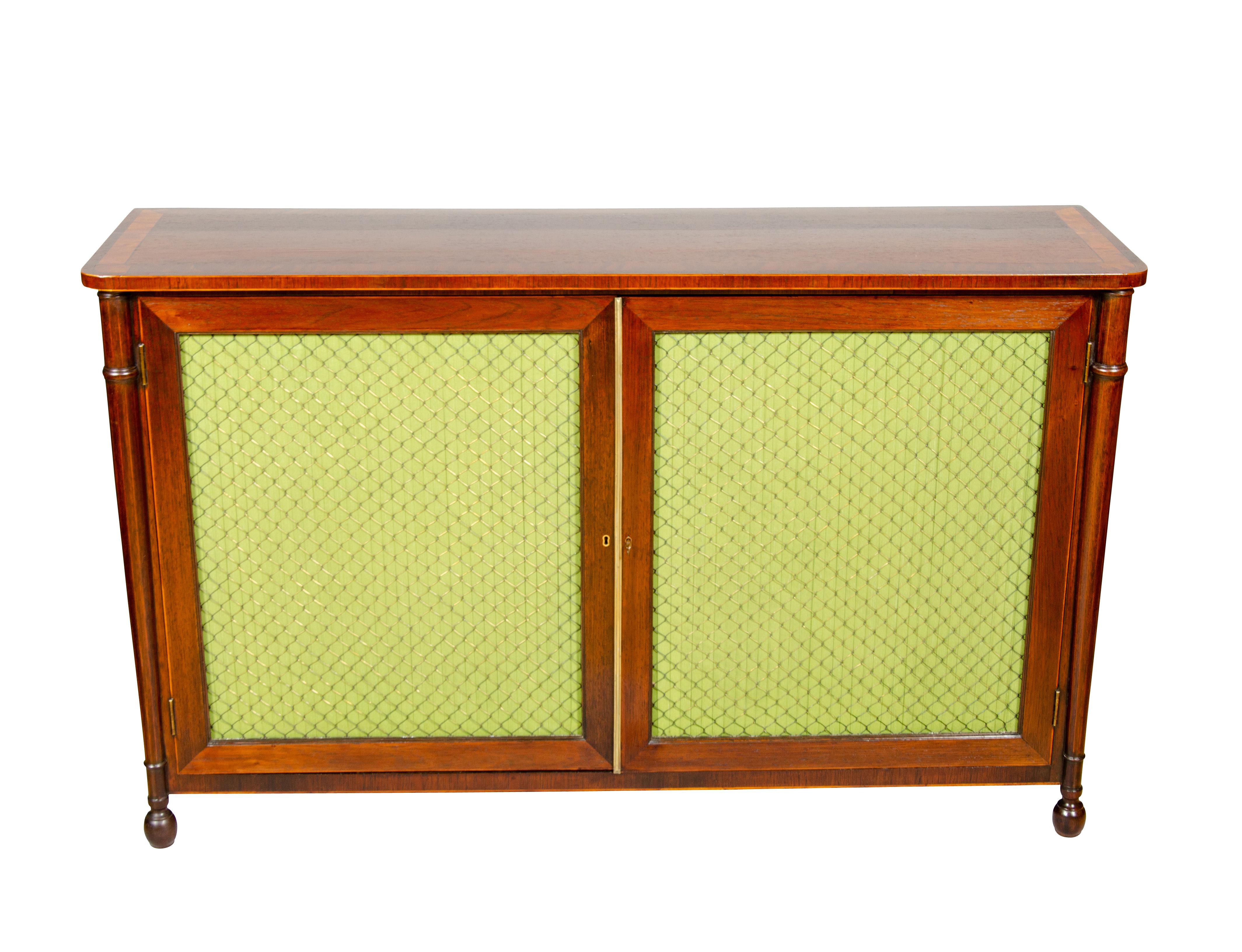 Rectangular top with banded edge over a pair of cabinet doors with wire grills enclosing two shelves, raised on turned legs. Ex Christies Ny Sale.