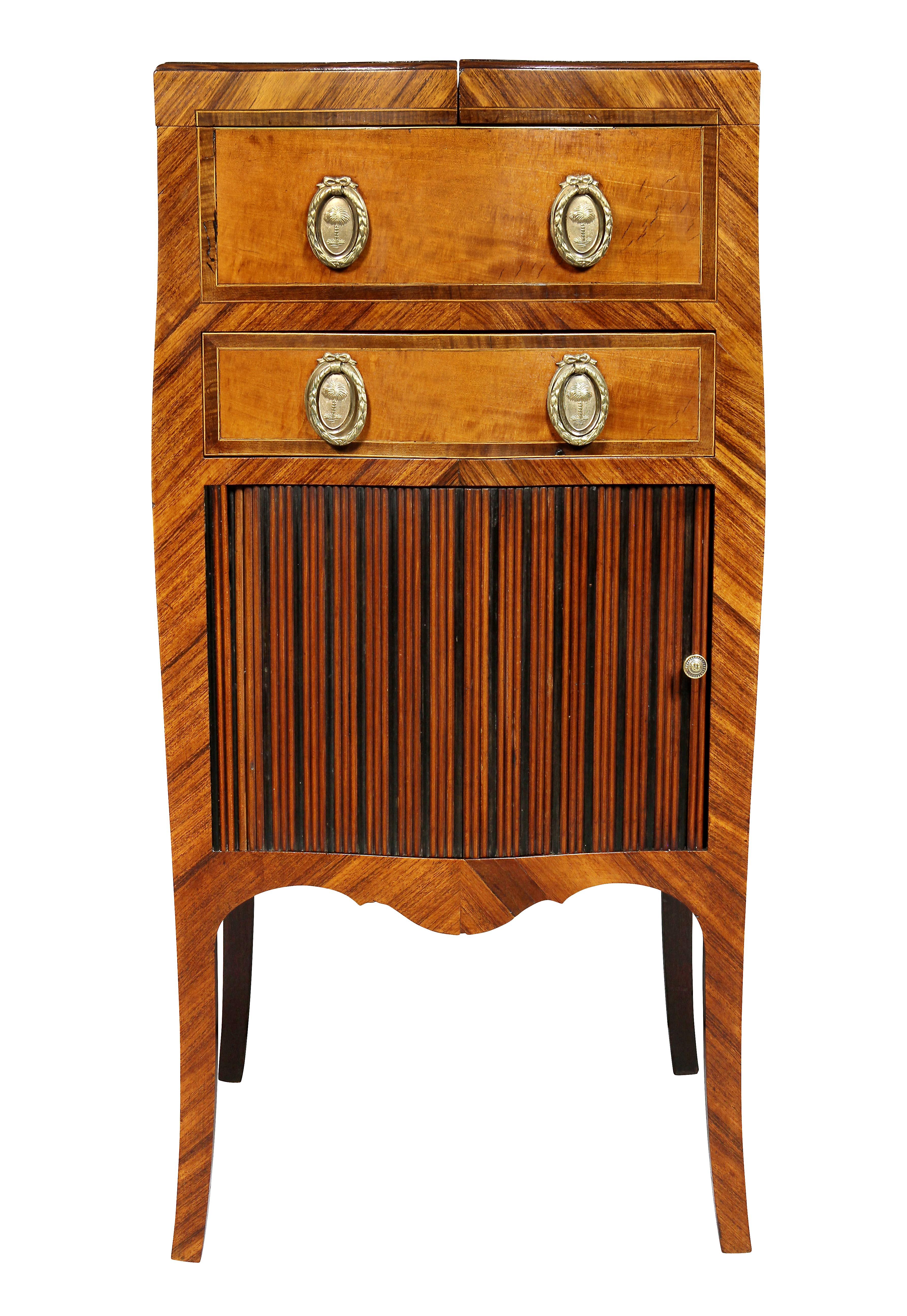 In the French taste with hinged square top with satinwood oval inlay opening to expose a compartment over a false drawer and a working drawer over a tambour door, slightly splayed legs. Original brass hardware.