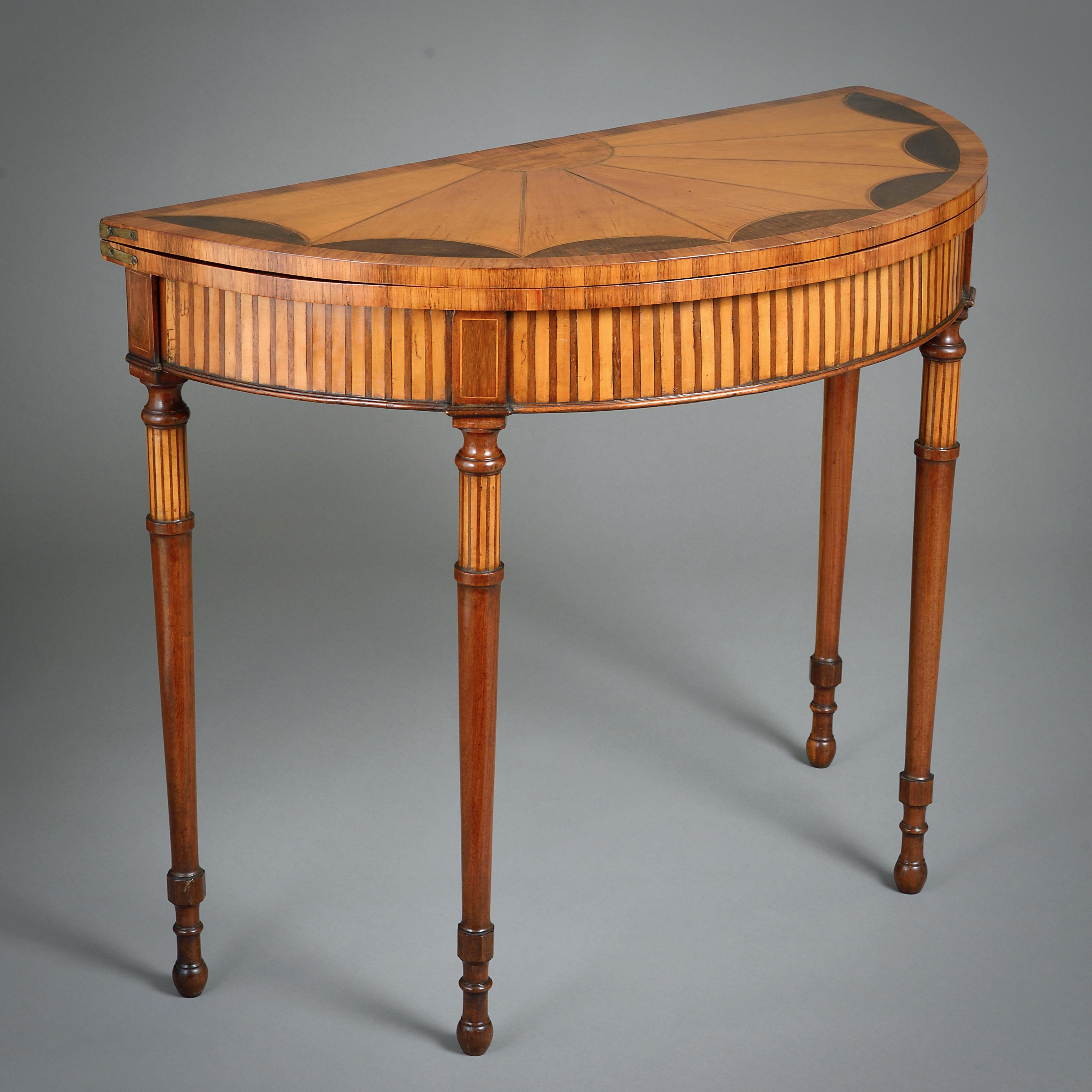TABLE À CARTES DEMI-LUNE EN BOIS DE SATIN ET ACAJOU DE GEORGE III, VERS 1790.

Incrustation de fustic, de bois de roi et d'amarante. Le Foldes est doublé de baize verte.