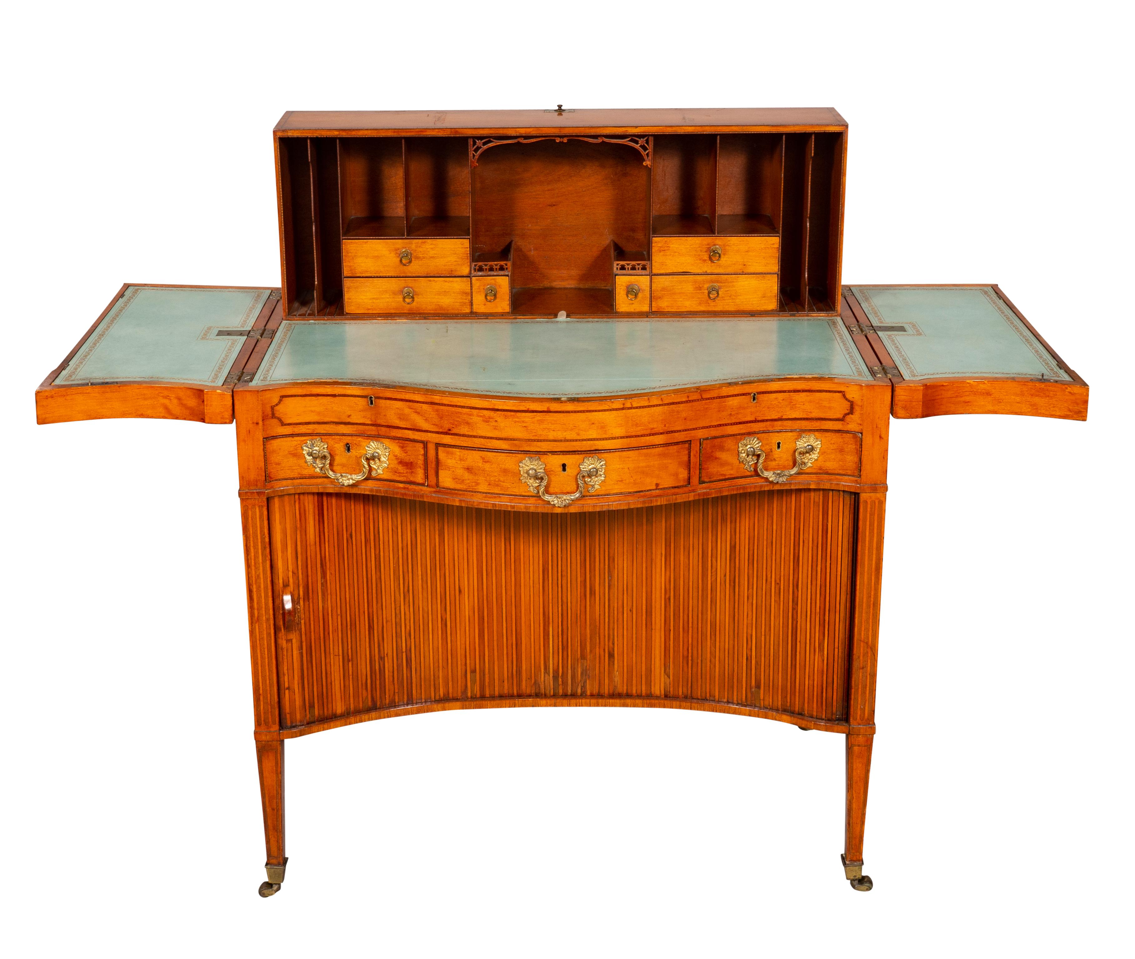 With a serpentine divided top with oval inlaid panel with hunting scene with hounds and hares with floral medallions at the corners , hinged outer sections fitted with a well and central section lifting and fitting into a recess , leather top of