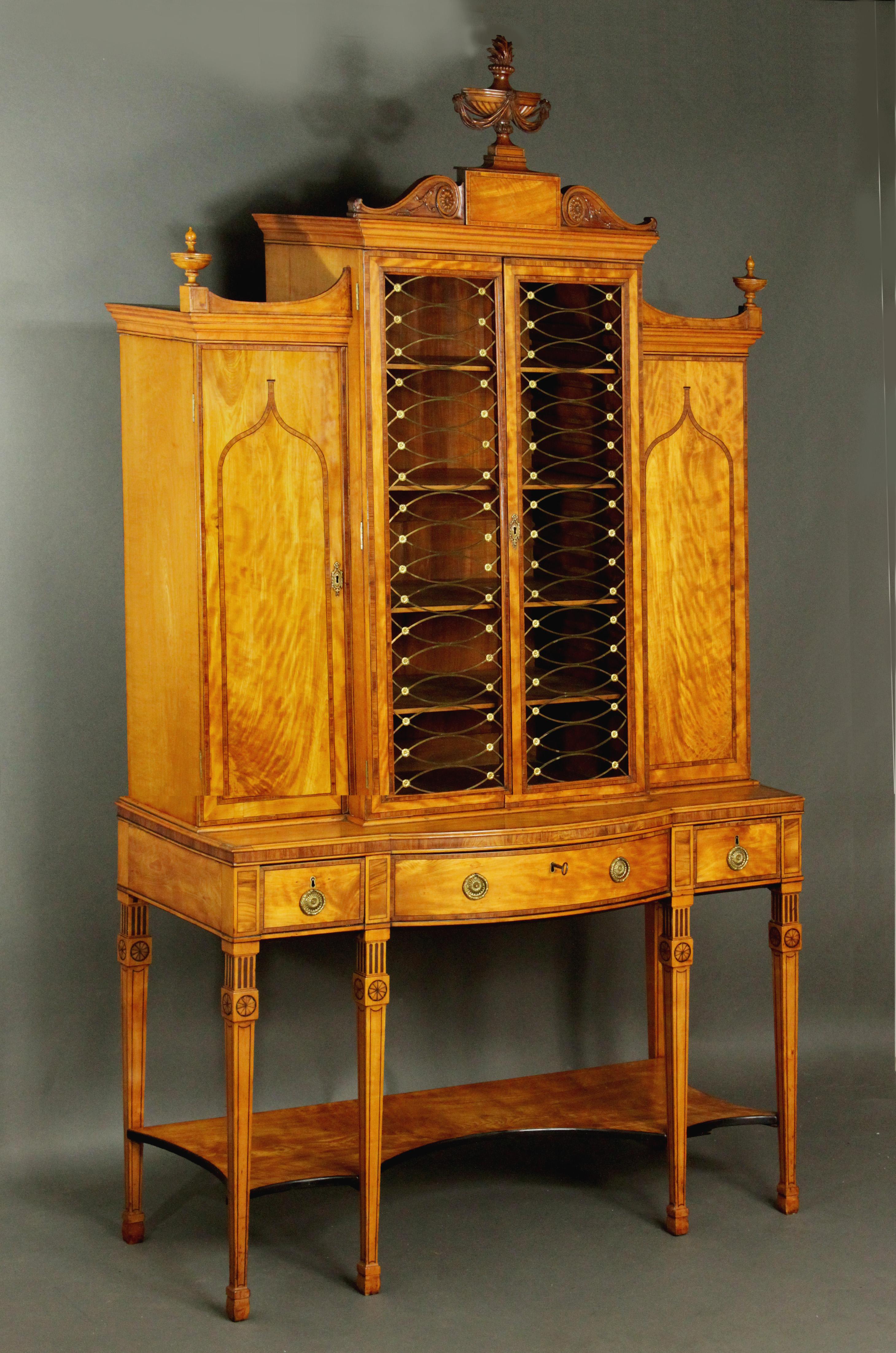 An exceptional George III satinwood breakfront cabinet in the manner of Thomas Sheraton with kingwood and box wood and ebony stringing. Although the design for the bookcase does not appear in the Sheraton Director, many of its characteristics are