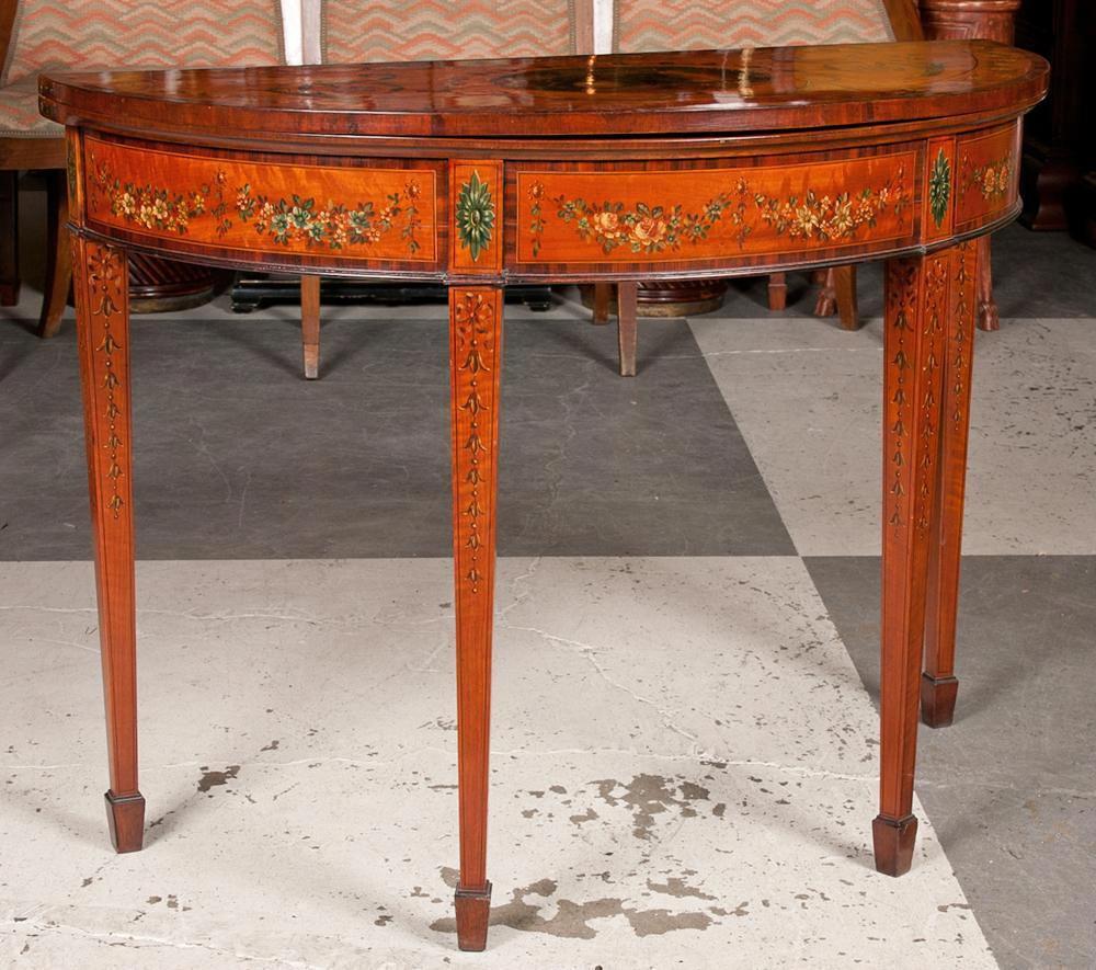 A George III Adam style satinwood and painted game table with double swing legs with rosewood crossbanding, square tapered pegs on spade feet.