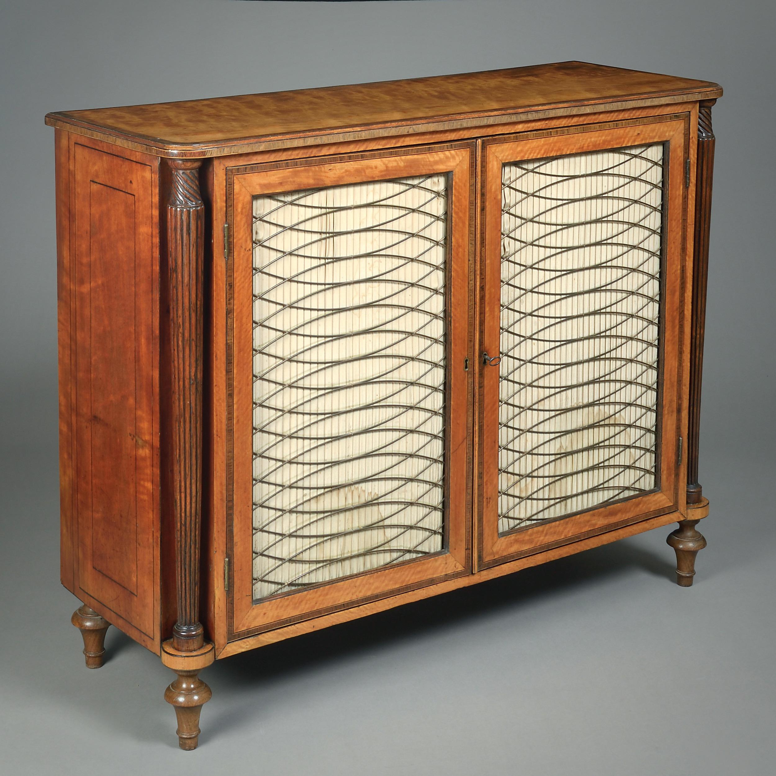 A FINE GEORGE III SATINWOOD, ROSEWOOD AND SIMULATED ROSEWOOD SIDE CABINET, CIRCA 1790.

Cross-banded in rosewood, the reeded column angles in simulated rosewood, the turned feet in rosewood. The interior with two original adjustable mahogany shelves.