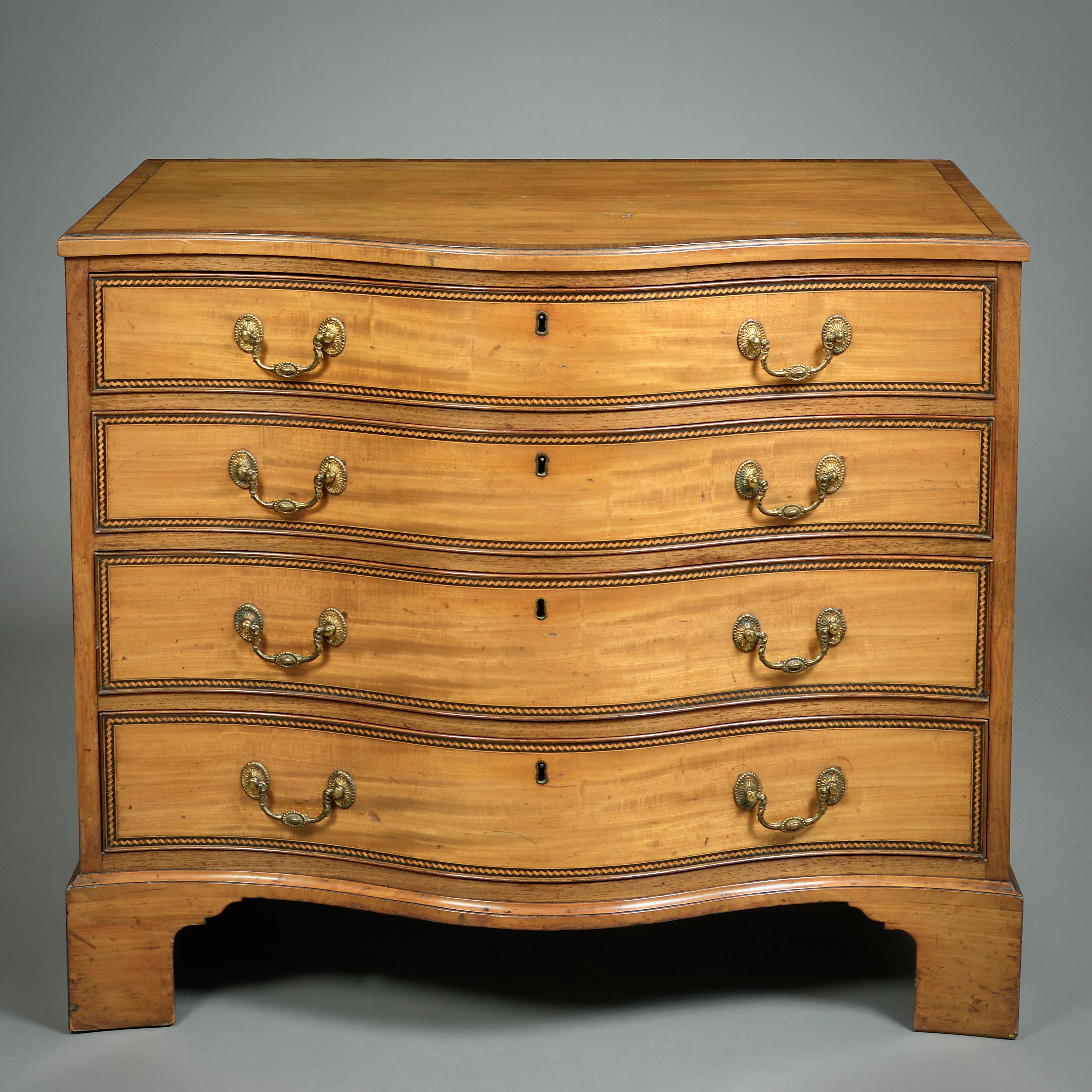 UN'ELEGANTE COMMODE DI GEORGE III IN LEGNO SATINATO, CIRCA 1780.

I cassetti sono bordati con una fascia trompe l'Oeil a zig-zag in legno di tulipano.