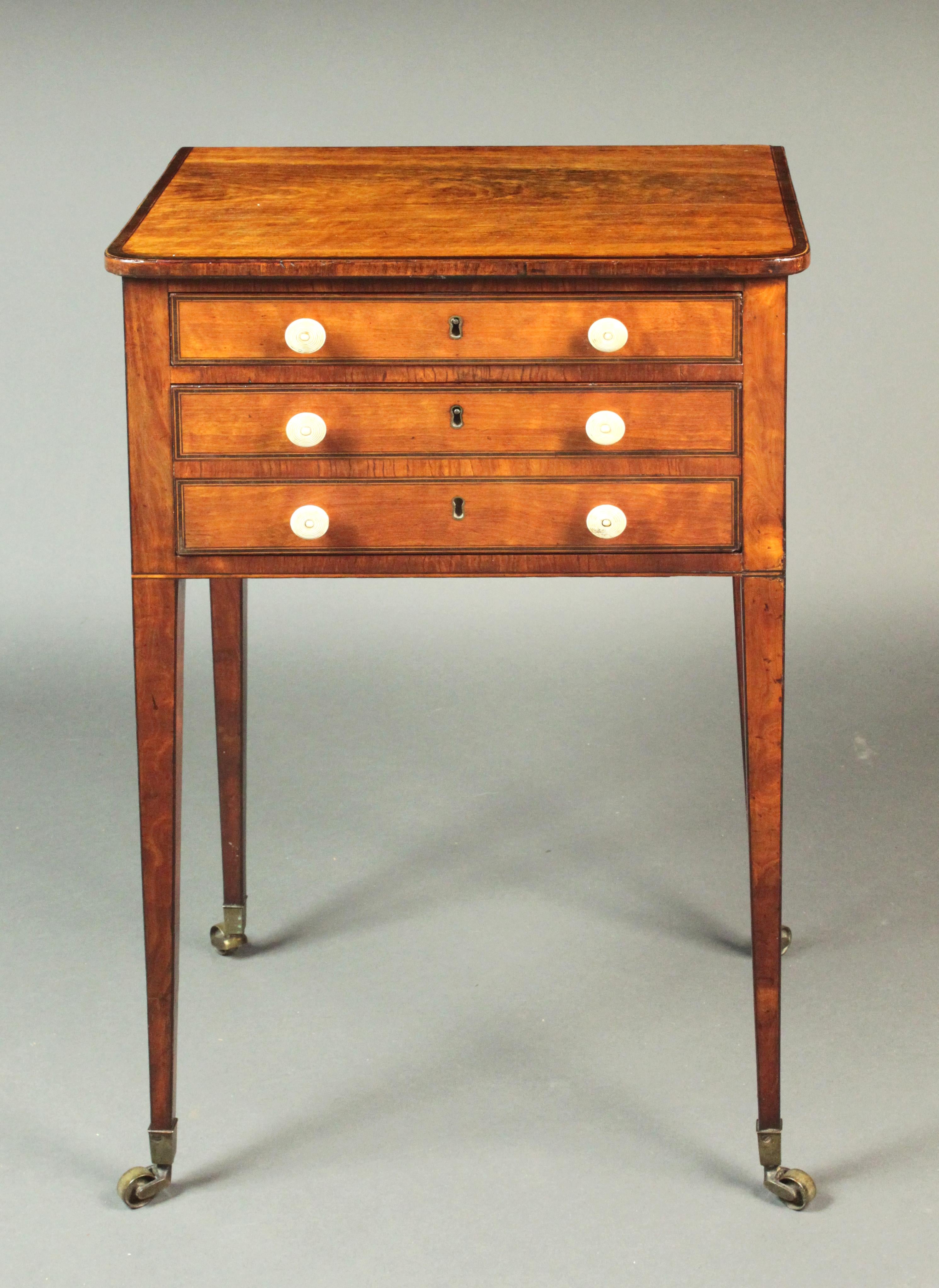Fine George III Sheraton Period satinwood sewing table; fitted top drawer, two candle slides and an ink drawer at the side; the back with a folding flap and an additional wooden hook to hold a sewing bag or basket.
Boxwood and ebony stringing on the