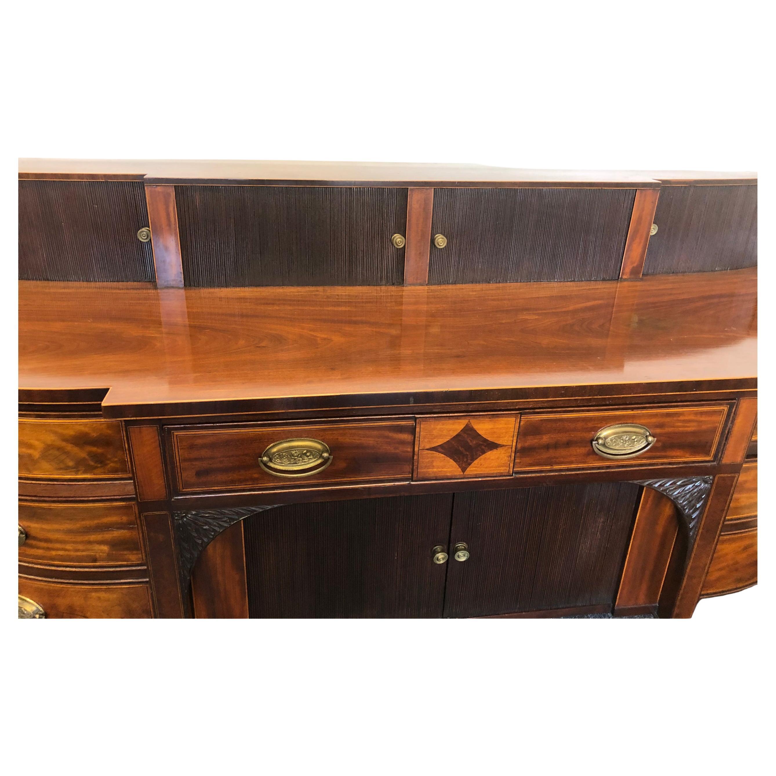 A fine quality mahogany Georgian Scottish sideboard with a stepped raised upper section and typical Scottish design. Featuring sliding tambour doors on the upper and lower sections. Squared tapered legs with carved capitals and period brasses.