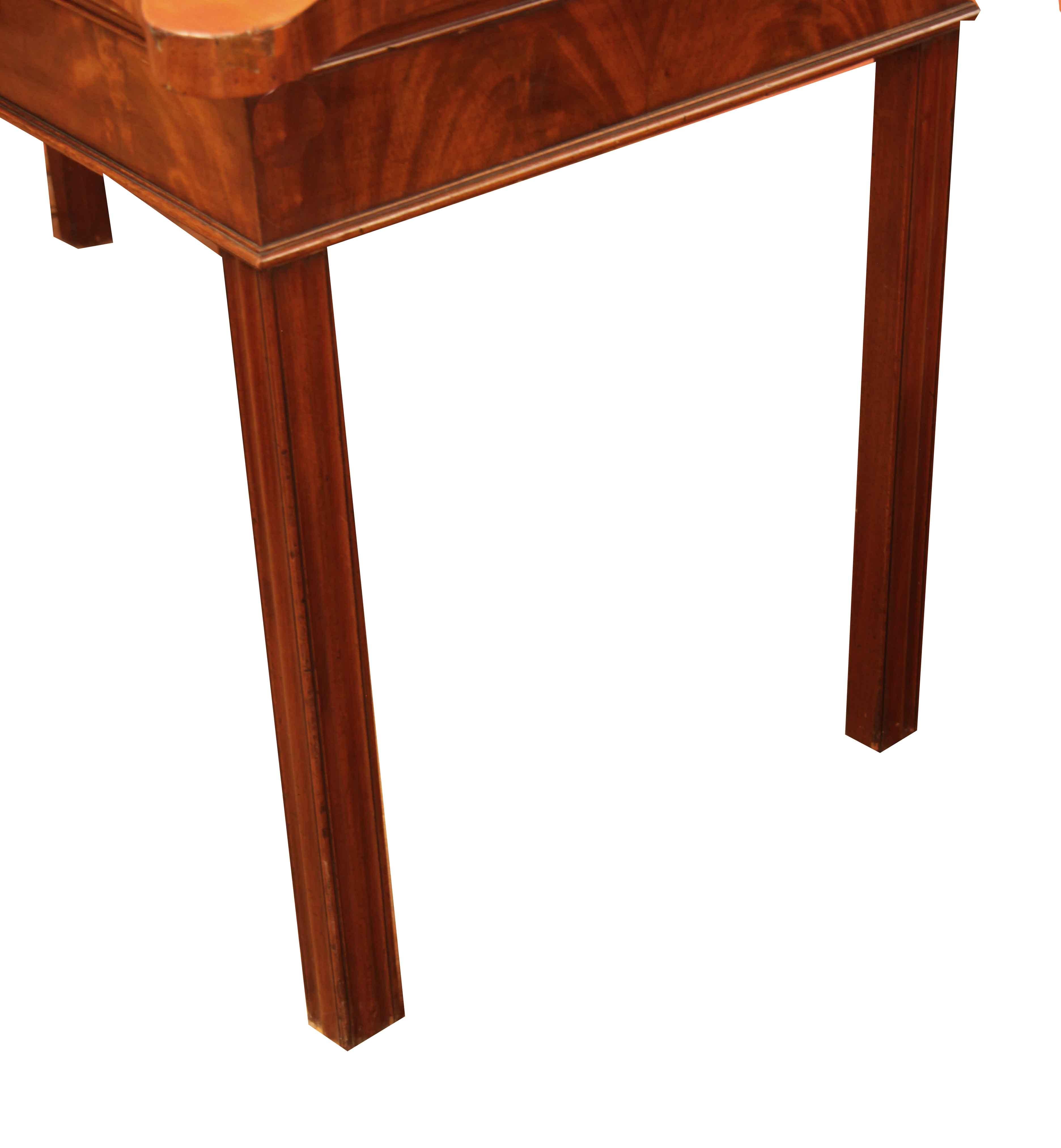 George III serpentine console table, the remarkably wide one board top with beautiful grain and color has a bold yet graceful serpentine shape, sides of the top are shaped as well; the flat edge of the top is cross banded in mahogany, this above a