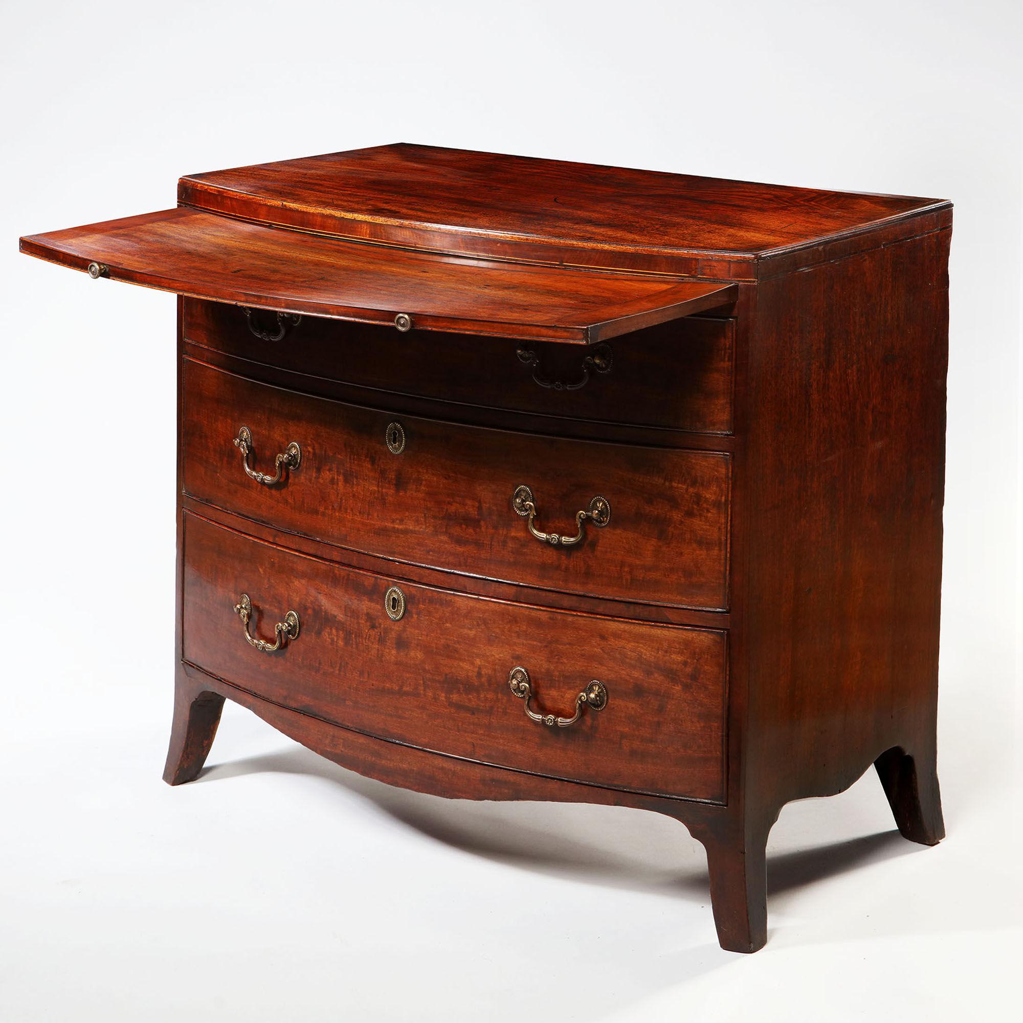 A fine George III Sheraton period bow-fronted mahogany chest of drawers with brushing slide. The chest has the perfect time aged color to its original wax finished surface and has truly commendable proportions. I love everything about this