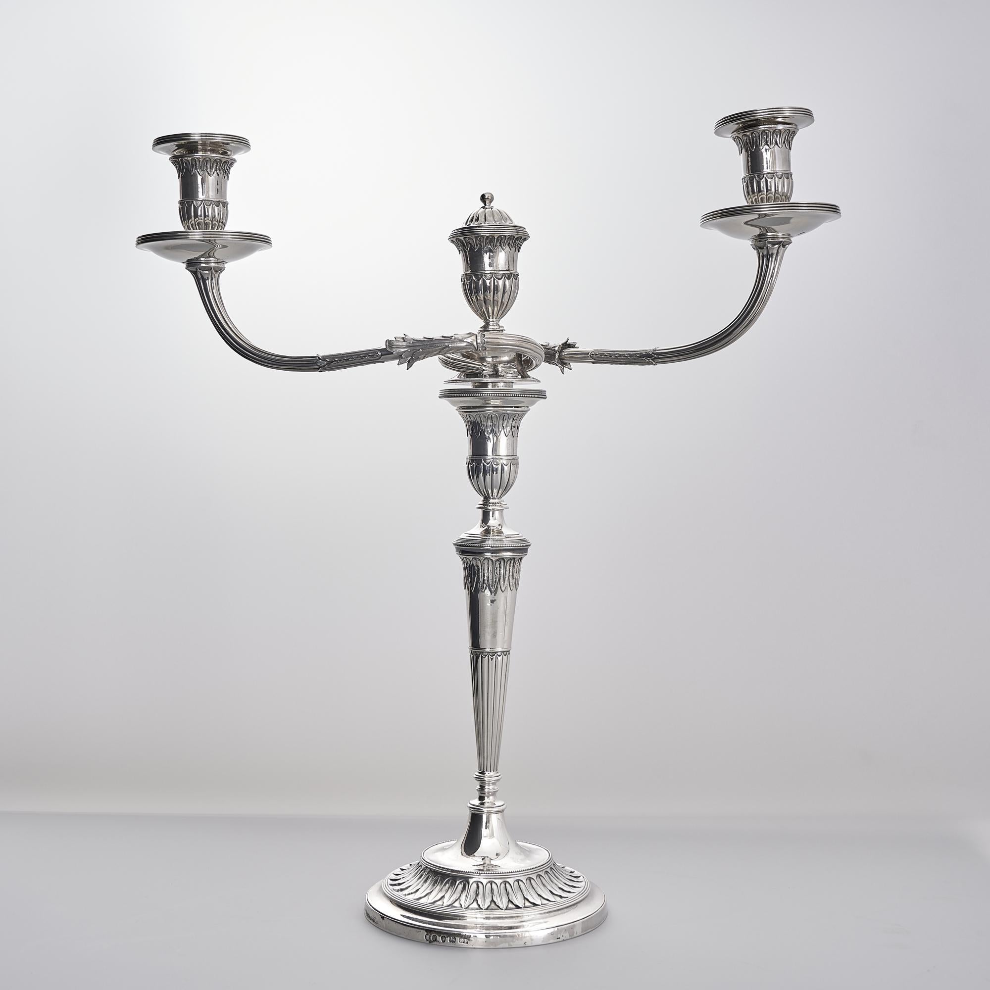 Suite of round-based George III silver candlesticks and candelabra with tapering stems and three-light arms made to the highest quality.  As a particularly attractive set in the neoclassical style of the mid 18th century, this suite incorporates two