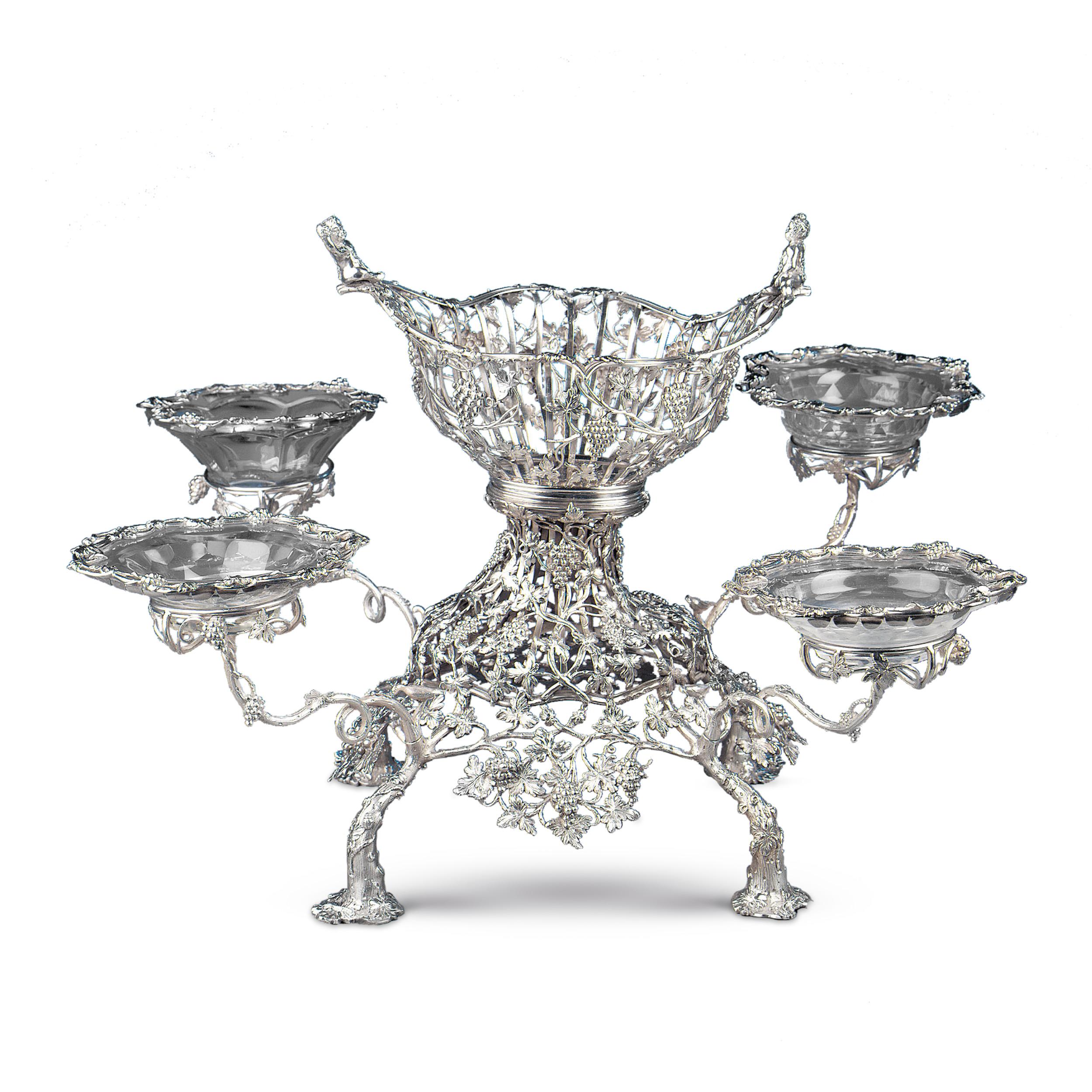 A remarkable Georgian sterling silver epergne by London silversmiths John Lawford and William Vincent. The entire epergne is beautifully embellished with fruits and vines, and the central basket is surmounted by two delightful cherubs. The four