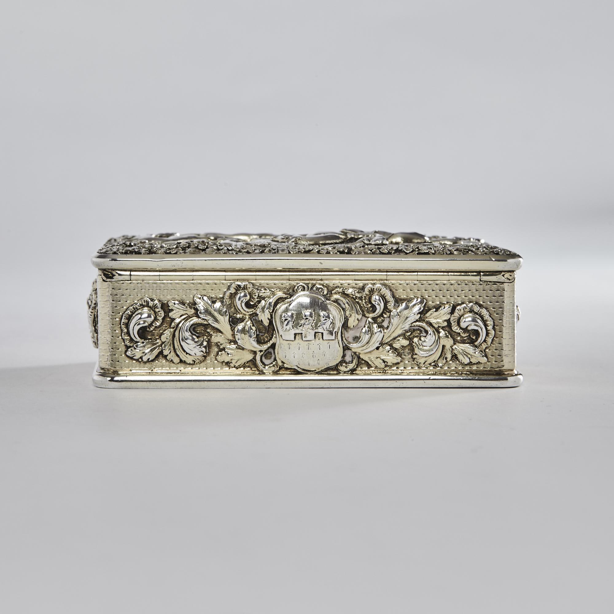 Fine Georgian snuff box with cast scene on the lid of huntsmen and hounds chasing a fox through the woods. The sides of the box have cast and applied foliate cartouches incorporating crests and arms for Williams of Dorset. This exceptionally heavy