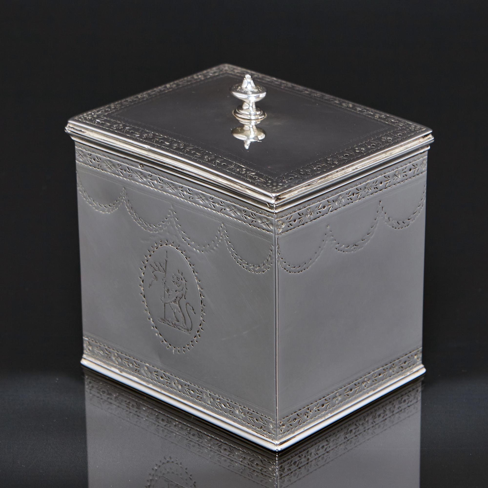 Klassische silberne Teedose aus dem späten 18. Jahrhundert in länglicher Form mit fein handgravierten Bändern und Bügeln an den Seiten und einem Klappdeckel mit ovalem, urnenförmigem Abschluss. 

Auf der einen Seite des Caddys ist ein Familienwappen