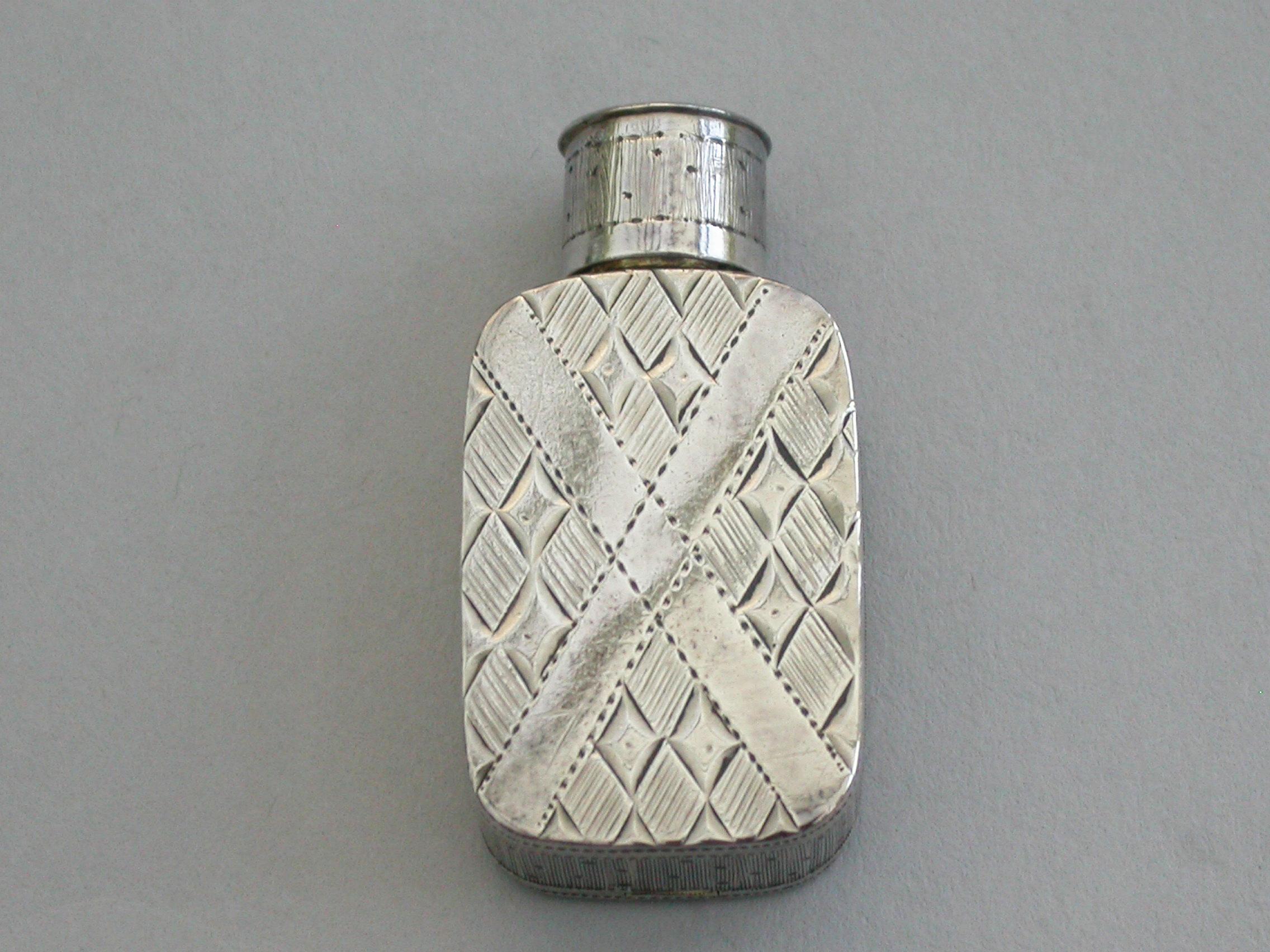 A small George III silver Vinaigrette formed as a Snuff Bottle, the hinged body engraved with a St.Andrew's Cross with alternate hatched diaper work between the arms. The pierced neck with screw on cap.

By Joseph Taylor, Birmingham, 1804


In