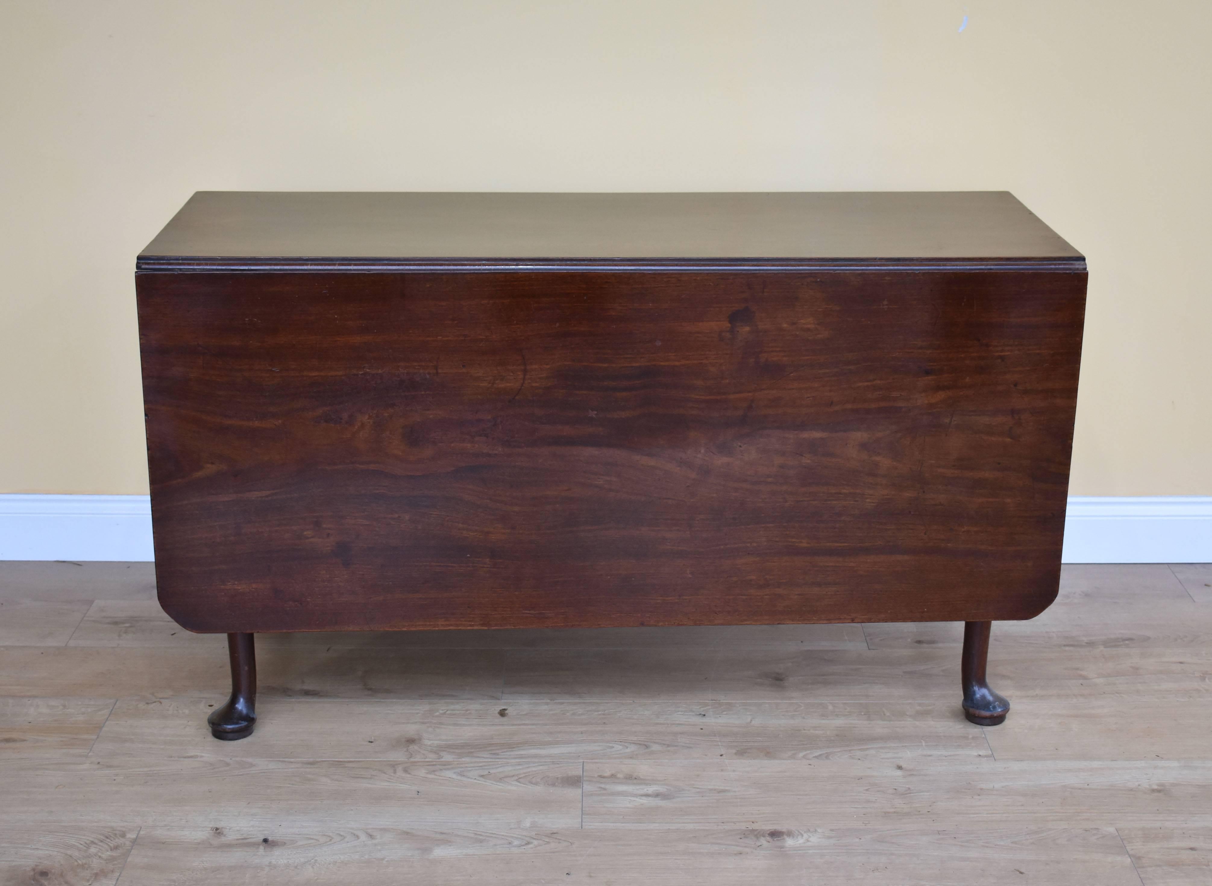 For sale is a good quality, George III solid mahogany drop-leaf dining table. The table has two large drop leaves, supported by fold out legs, each terminating on 