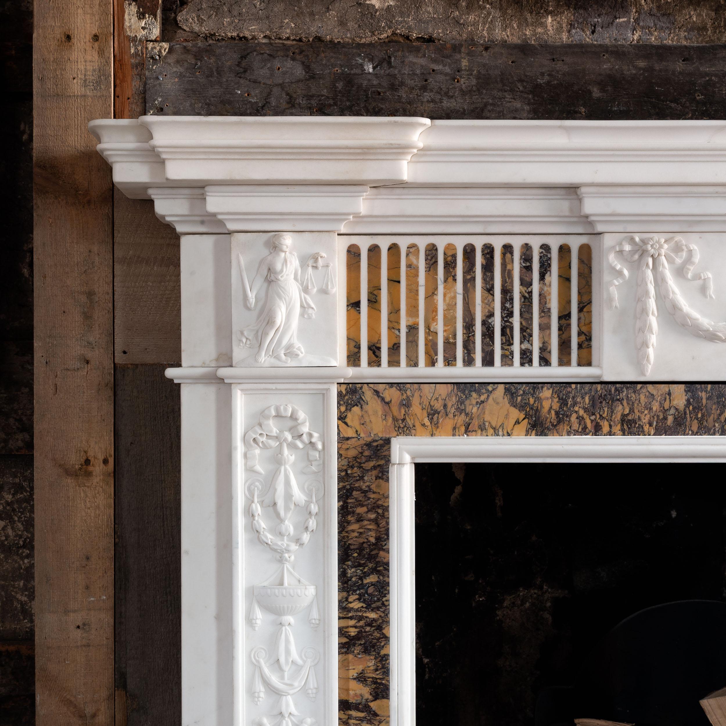 A George III Statuary and Convent Sienna marble fireplace, c.1790.  
The breakfront shelf with generous bed-mould, the frieze centred by relief carved plaque depicting a maiden, this flanked by panels of inlaid flutes and carved corner blocks, the