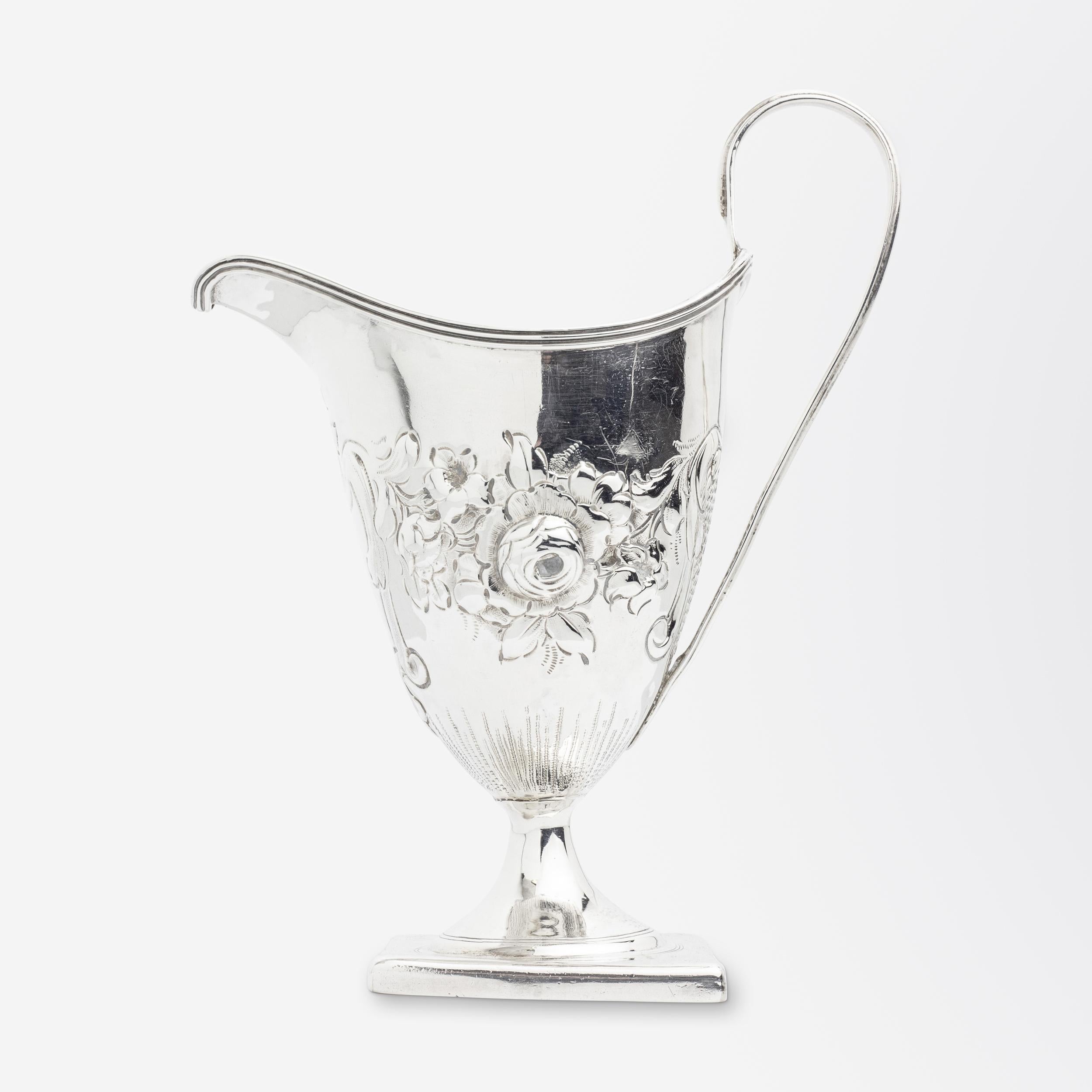 A George III period sterling silver creamer with floral repousse design to the body above a square base by Peter & Ann Bateman. To the centre of the creamer under the spout is a blank crest which is unusual for the Georgian period where the majority