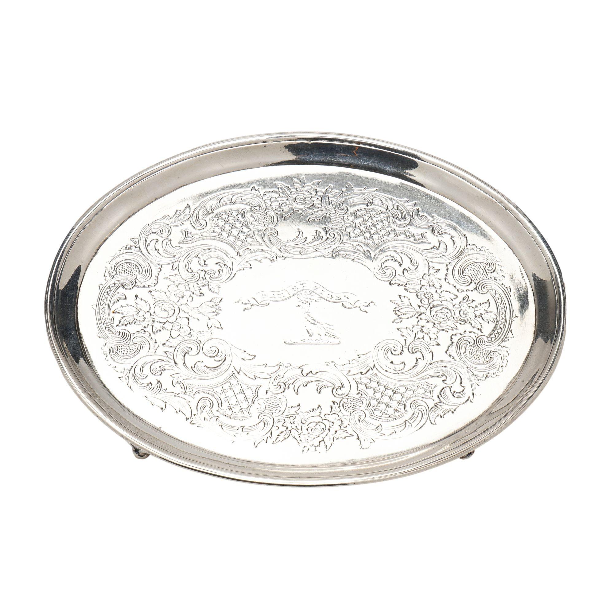 An oval standing rim sterling silver salver with four bracket feet. The center is engraved with a Latin motto (Peace & Faith) above a dove with laurel leaf twig in its beck. Later engraved embellishments surrounded the armorial. Hallmarked on the