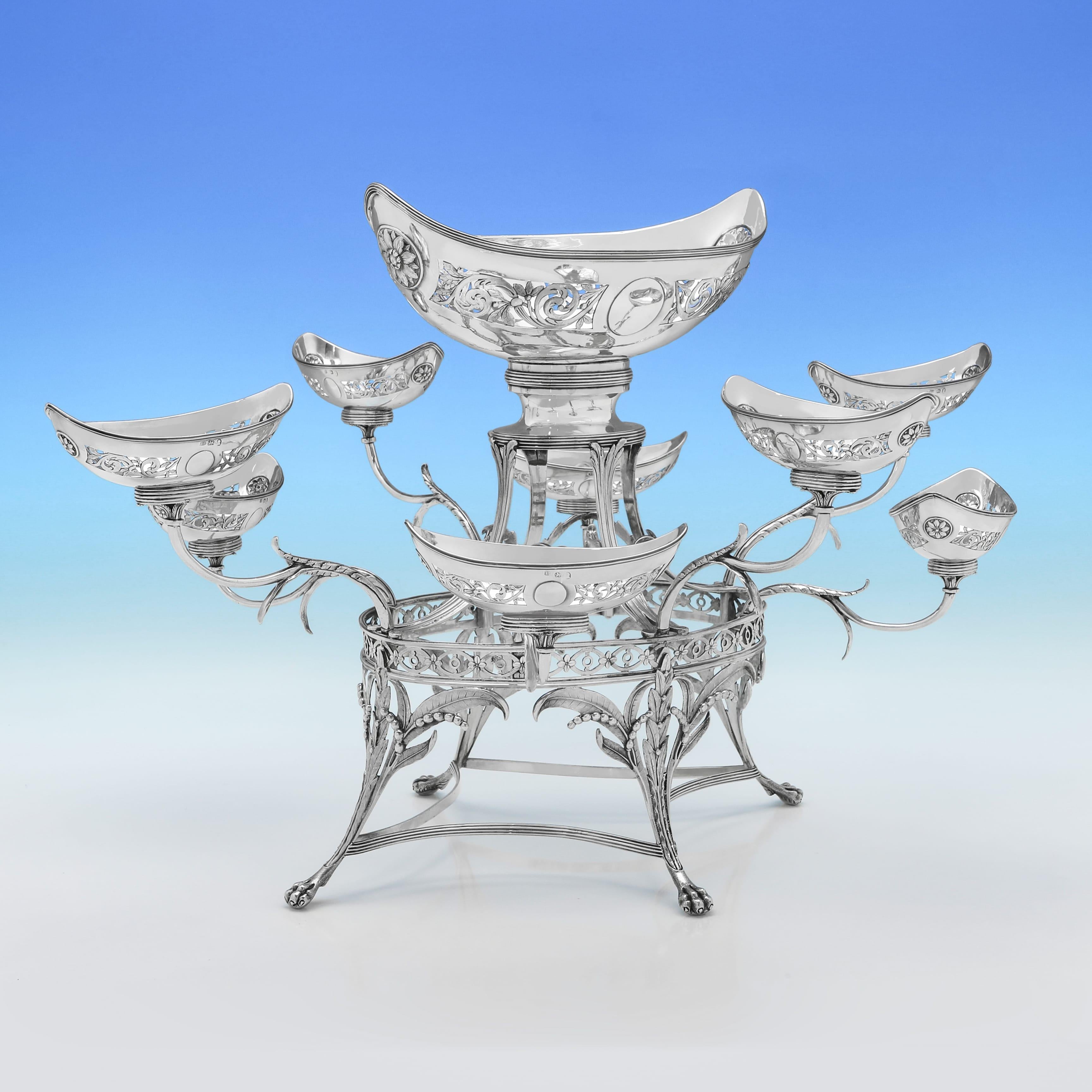 Hallmarked in London in 1790 by Thomas Pitts, this attractive, Antique, George III period, Sterling Silver Epergne, is in the Neoclassical style, standing on four ball and claw feet, and featuring cast, pierced and engraved decoration throughout,
