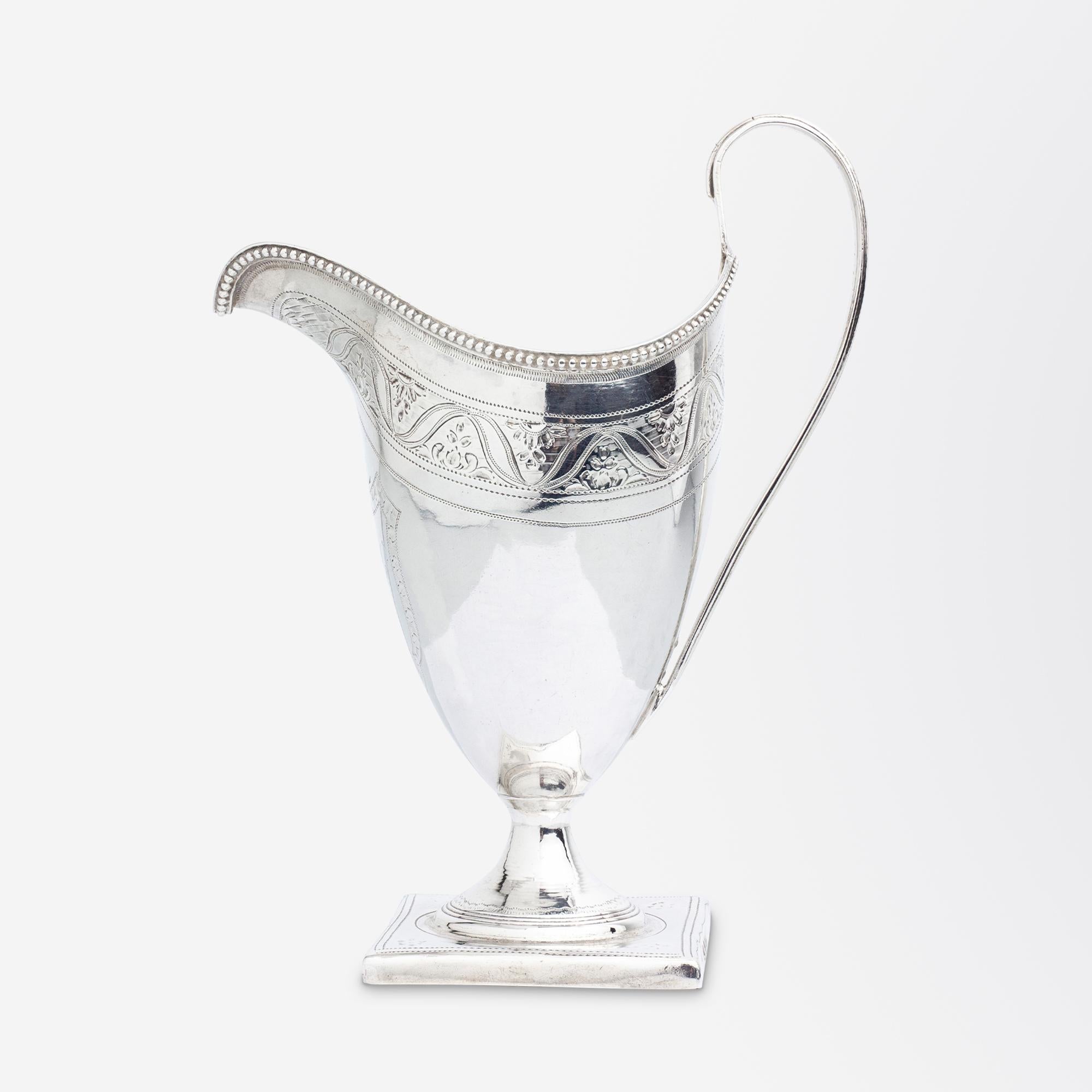 A George III period, sterling silver creamer with a monogrammed crest and beaded rim by Peter & Ann Bateman of the famed Bateman silversmithing family. This rather lovely creamer sits atop of a square foot and has an elongated handle typical of the