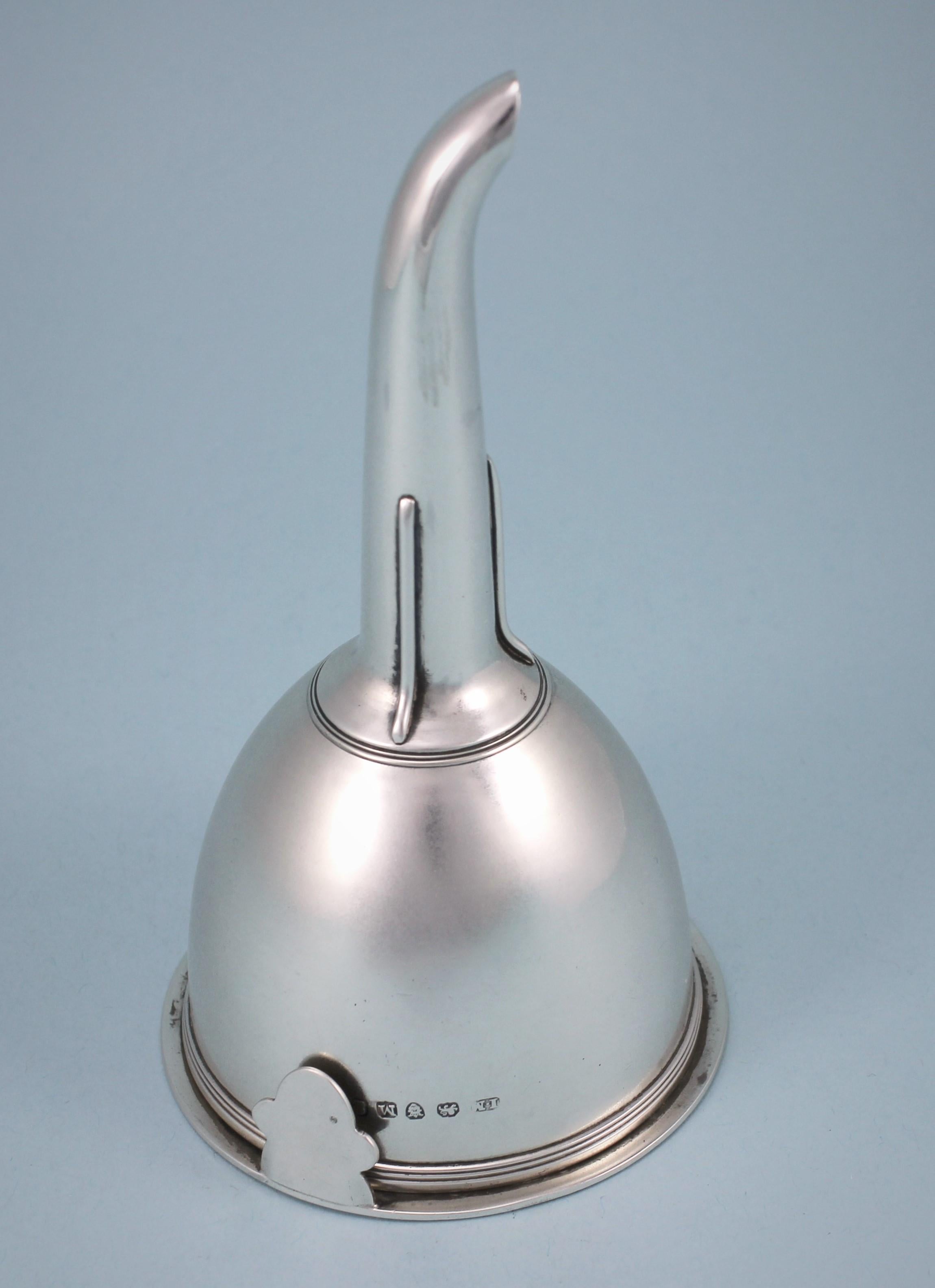 Simple and elegant George III sterling silver funnel, inclusive of ring. 
Maker: John Moore. London 1807. 

The body of this funnel is perfectly plain with the exception of a band of reeding at the rim and another one at the base of the spout.