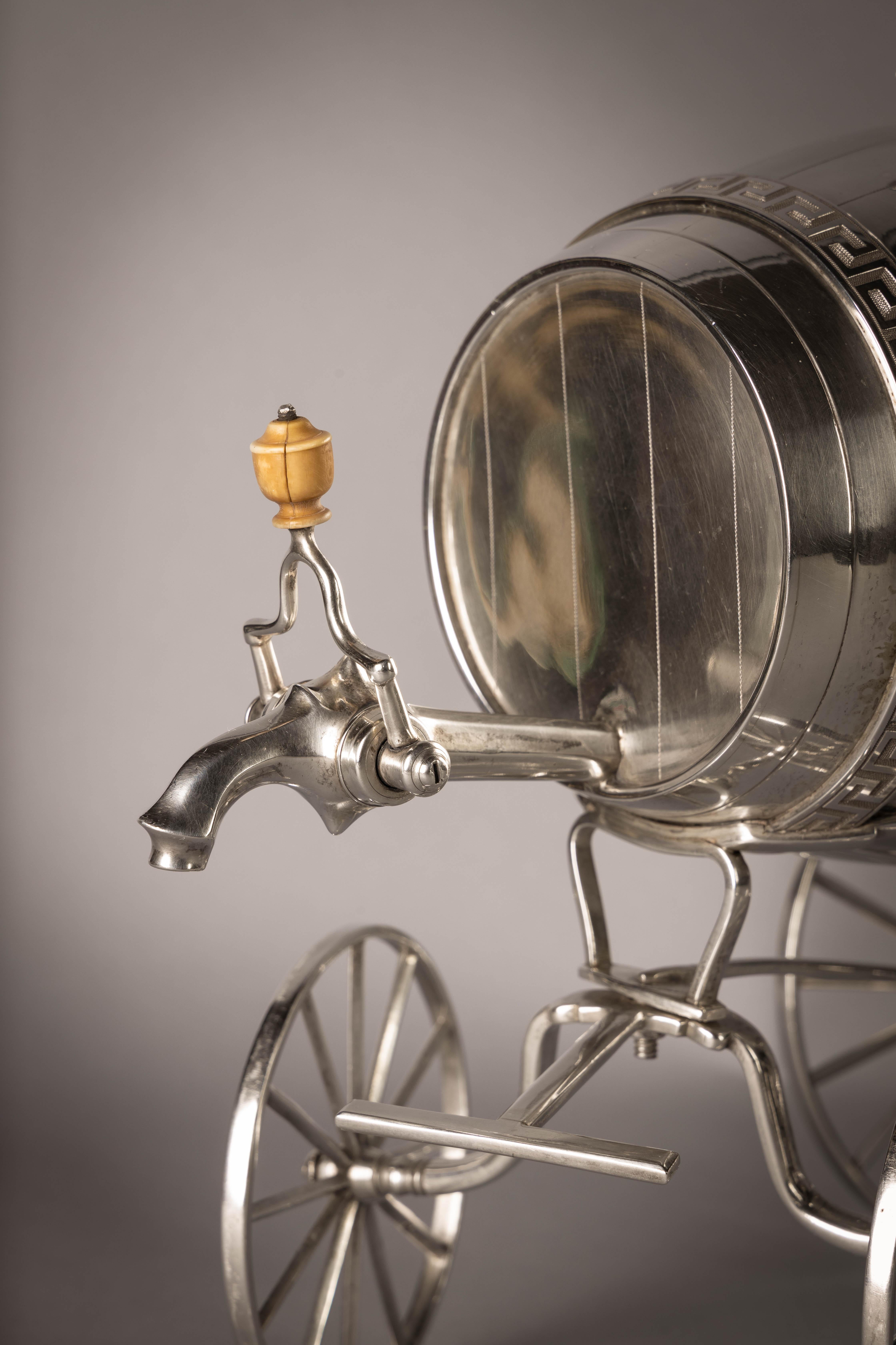 Modelled as a wine barrel on wheels with a detachable putti finial. Marked: London, 1807, Maker: William Burwash.