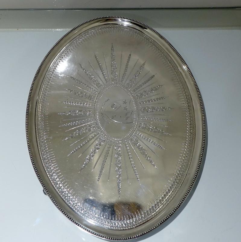 An extremely beautiful and stunning good quality large oval bead bordered salver. The front has outstandingly intricate “sun burst” bright cut engraving for decoration. There is a contemporary armorial on the centre front and a beautiful