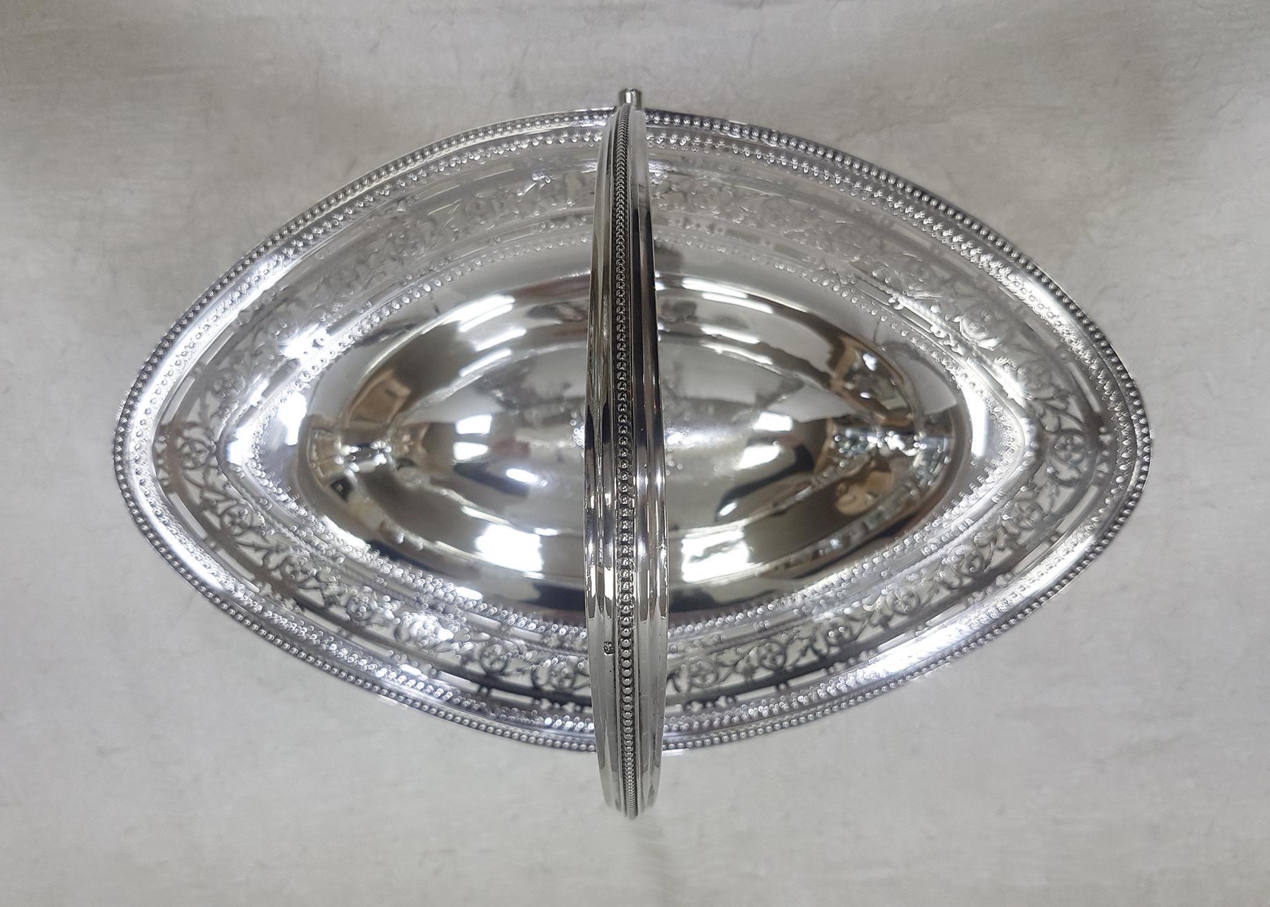 A George III sterling silver cake basket made by William Plummer in London, 1786. The basket is of Classic oval form with bead borders and an engraved pierced gallery and foot. There is also an original coat of arms to the centre. The length of the