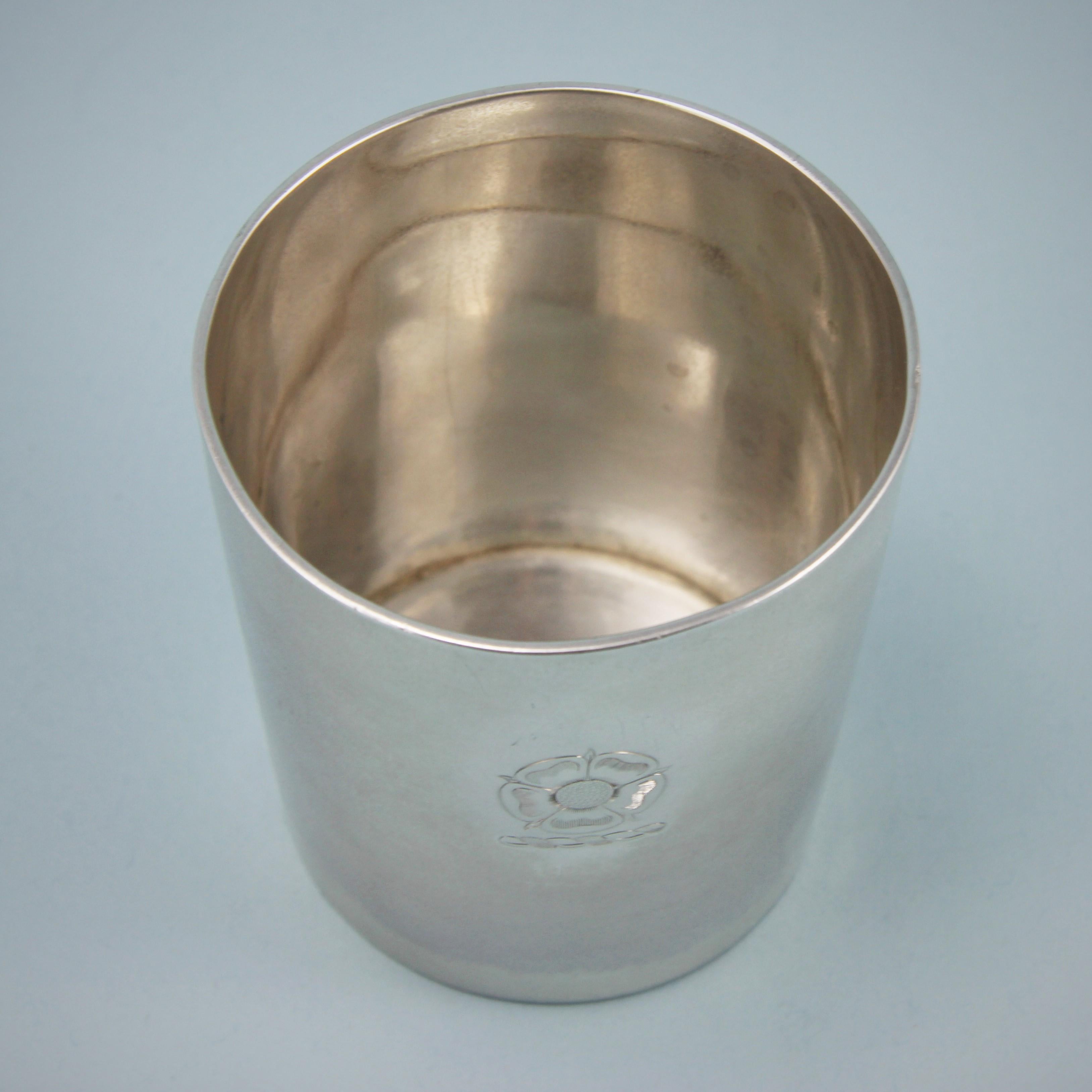 Elegant George III sterling silver pint beaker of good weight. 
Maker: Richard Sibley. London 1815. 

The beaker is plain apart from a crest of a stylised Tudor Rose which is possibly for Dorville or Dupre. Both of these names have been found as