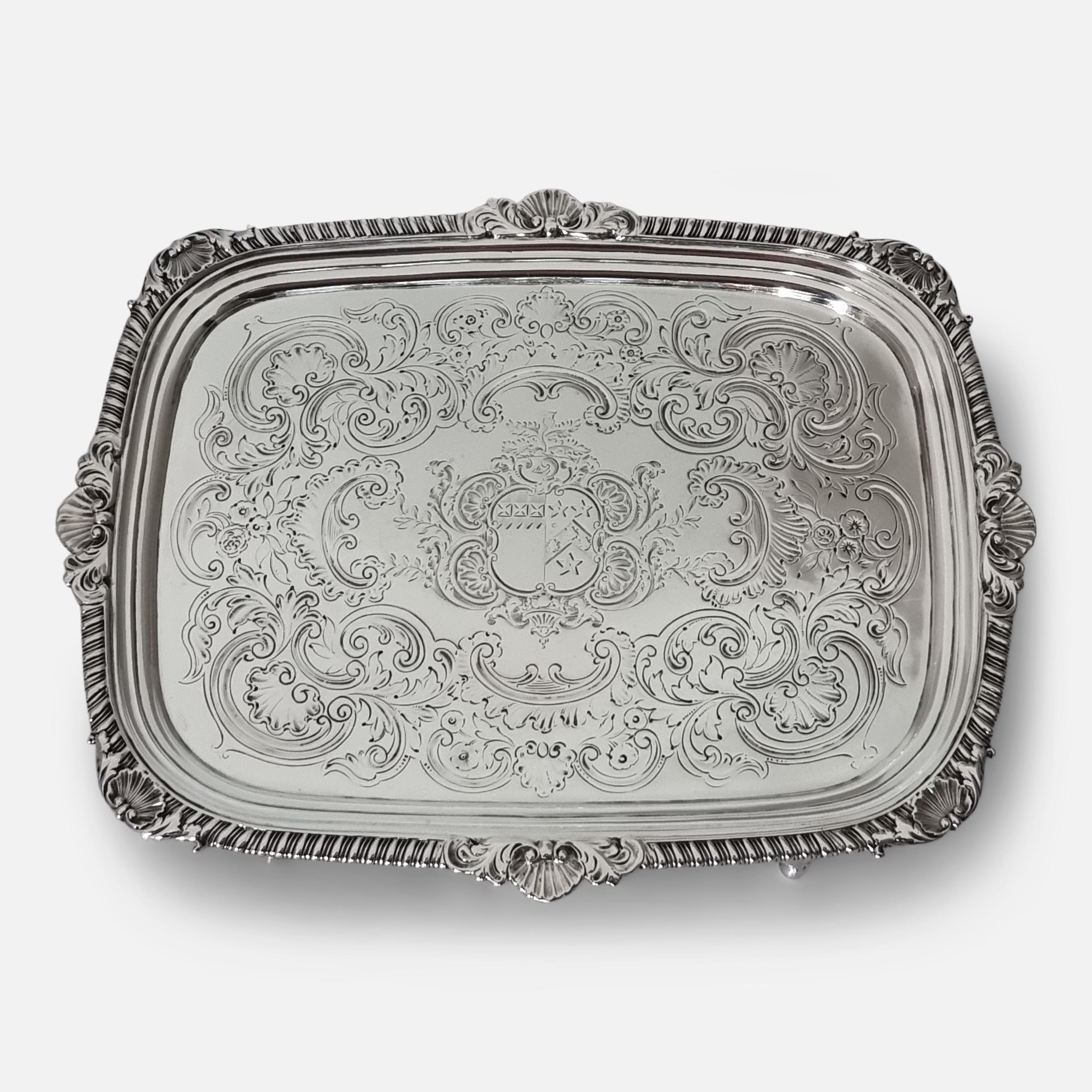 A George III sterling silver salver. The salver is of oblong form, with a gadrooned and shell border, engraved with C-scrolls, foliate swags, an armorial crest, on four ball feet.

The hallmarks are located to the reverse with the makers mark of