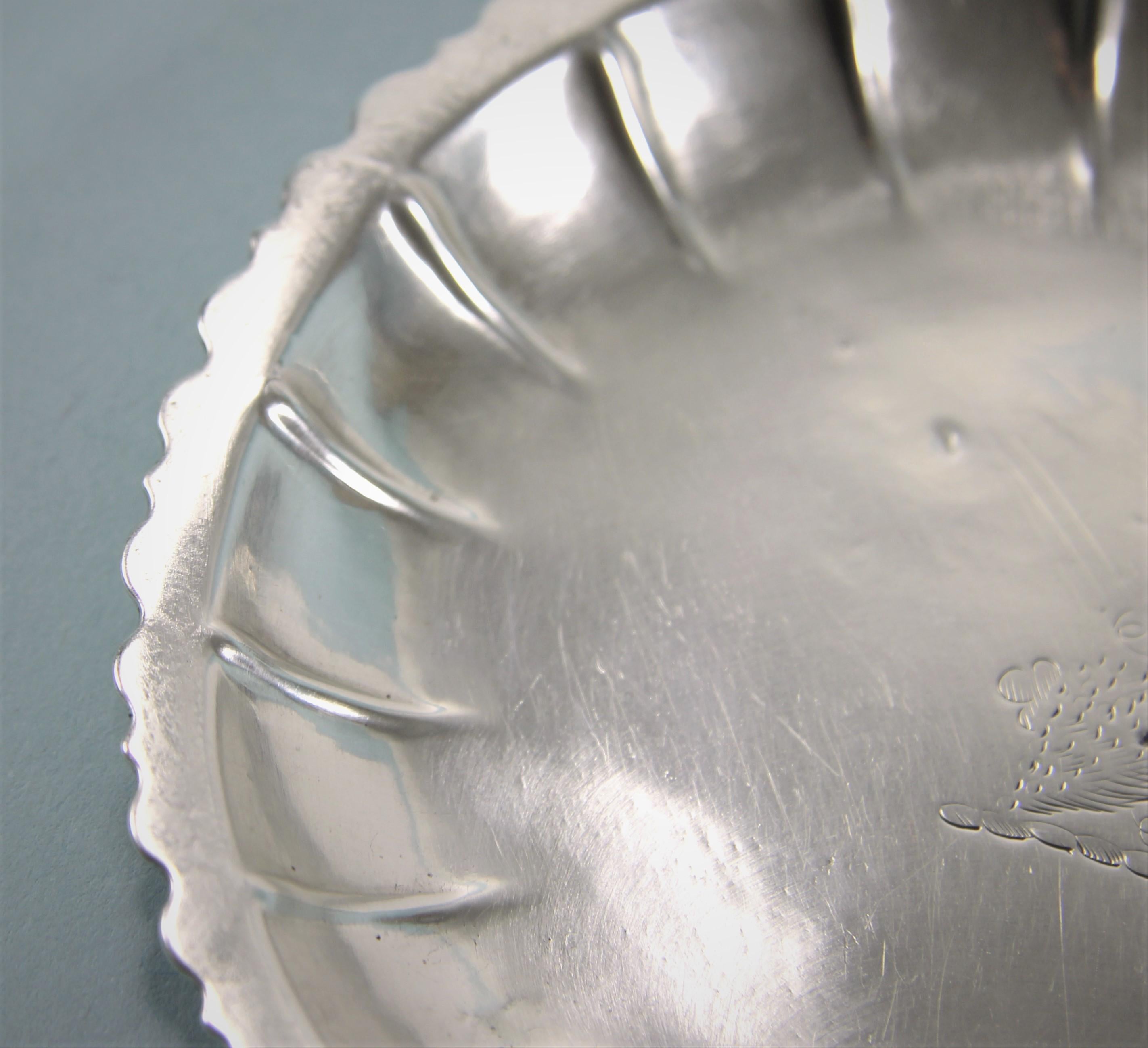 Attractive sterling silver small dish circa 1760, either very early George III or late George II. 
Maker: James Warren. 
The dish has a crenelated border with raised ridges beneath. A contemporary crest of a bunch of grapes with two shamrocks