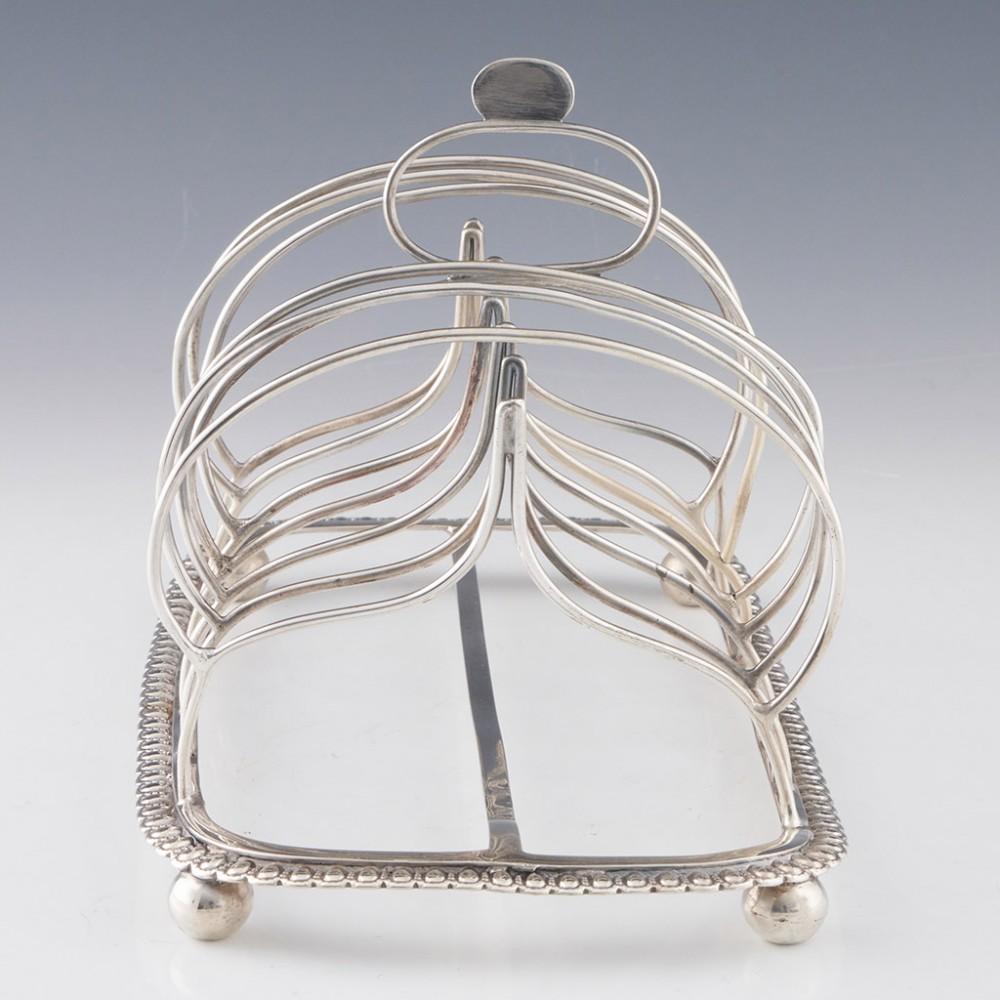 Heading : George III Sterling Silver Toast Rack
Date : Hallmarked in London 1815
Period : George III
Origin : London England
Decoration : Six division with Omega shape handle. Breaded border and ball feet
Size :  Height 12.3cm, base 19.1 x