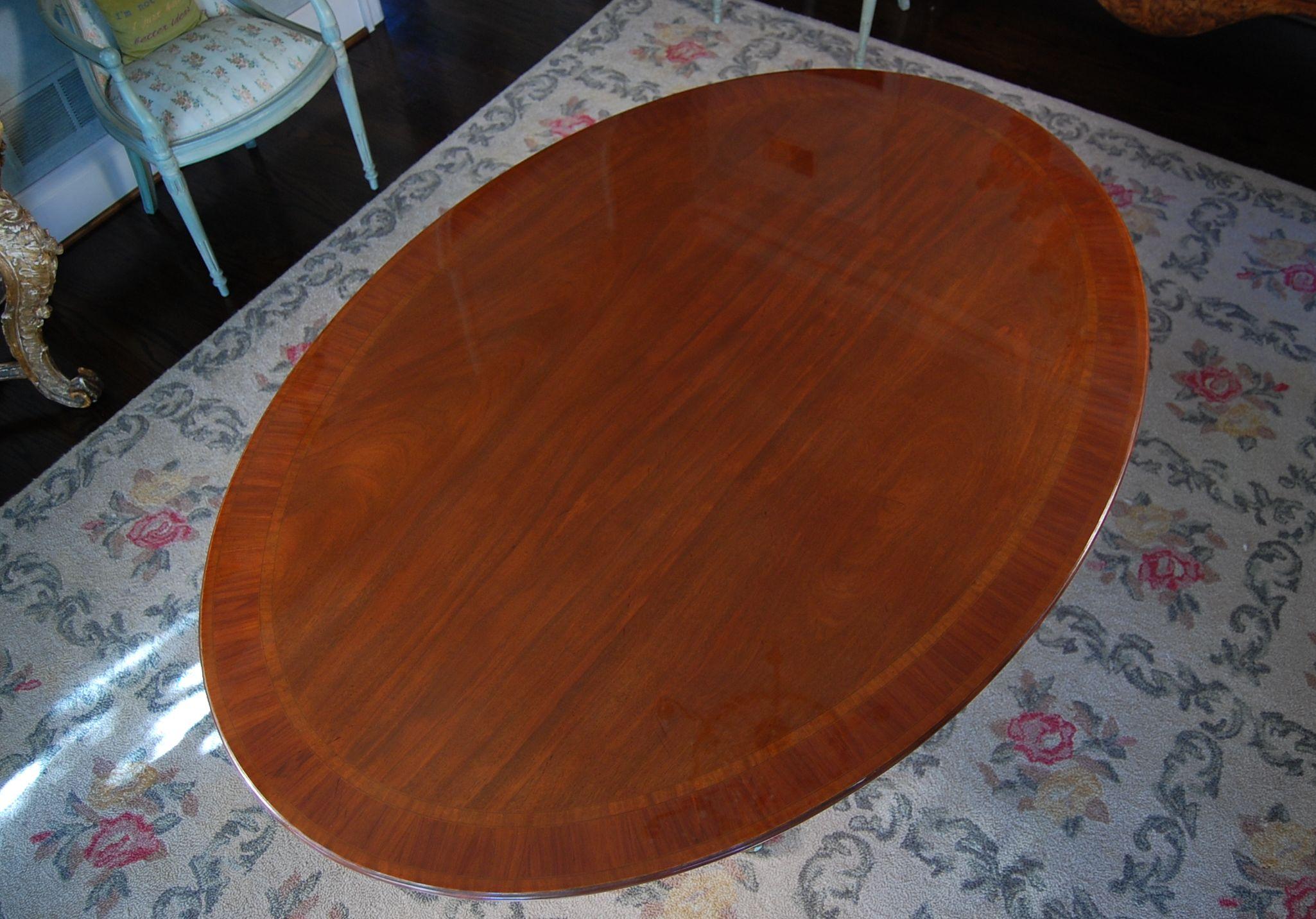 Oval English bench made mahogany table on single pedestal base with crossbanded top. This is a wonderful size and can be used as a dining room table, breakfast room or even as a small conference room table. This table has a satinwood banded edge