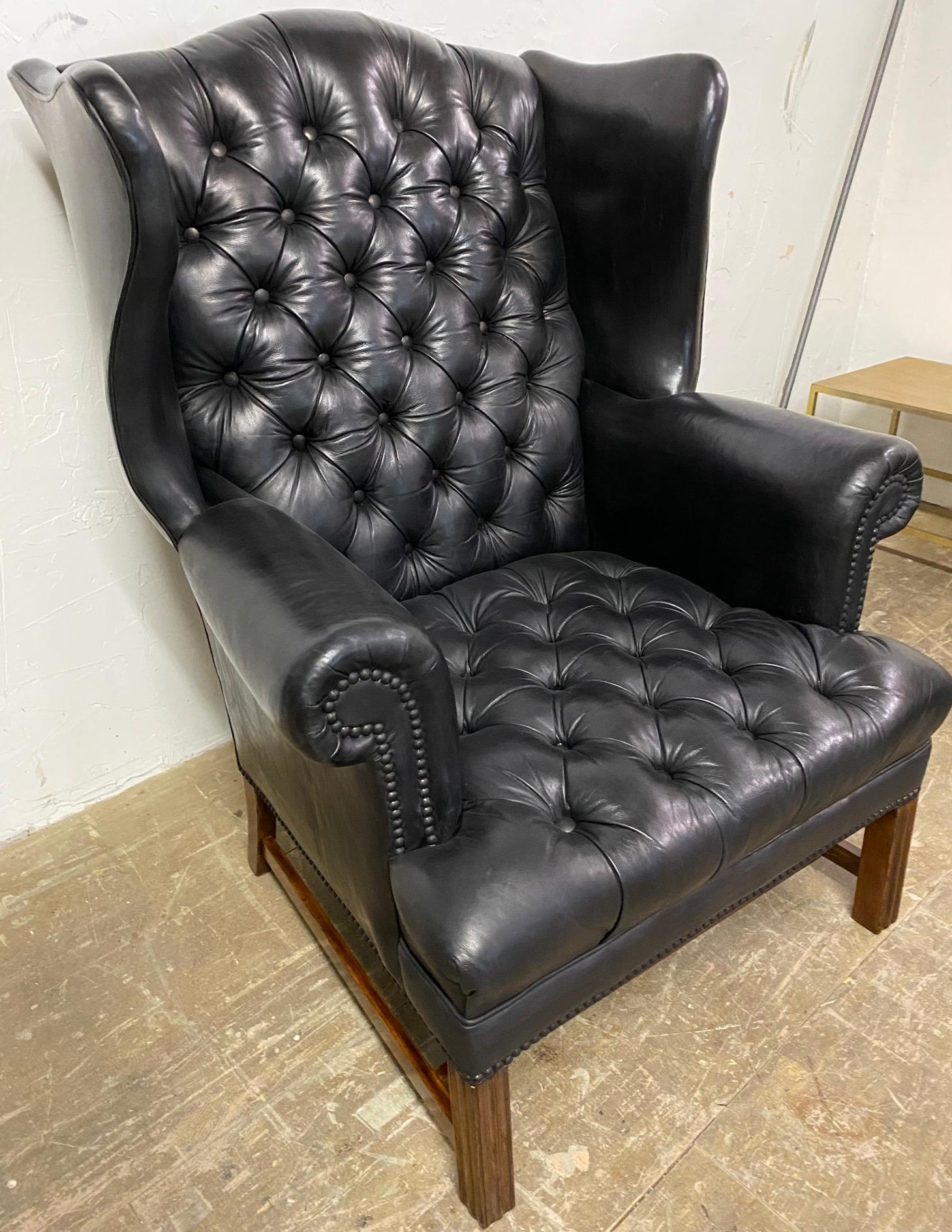Vintage George III style black tufted leather wing back armchair with a deep buttoned back. Comfortable with good back support. 
Measures: Arm height: 26