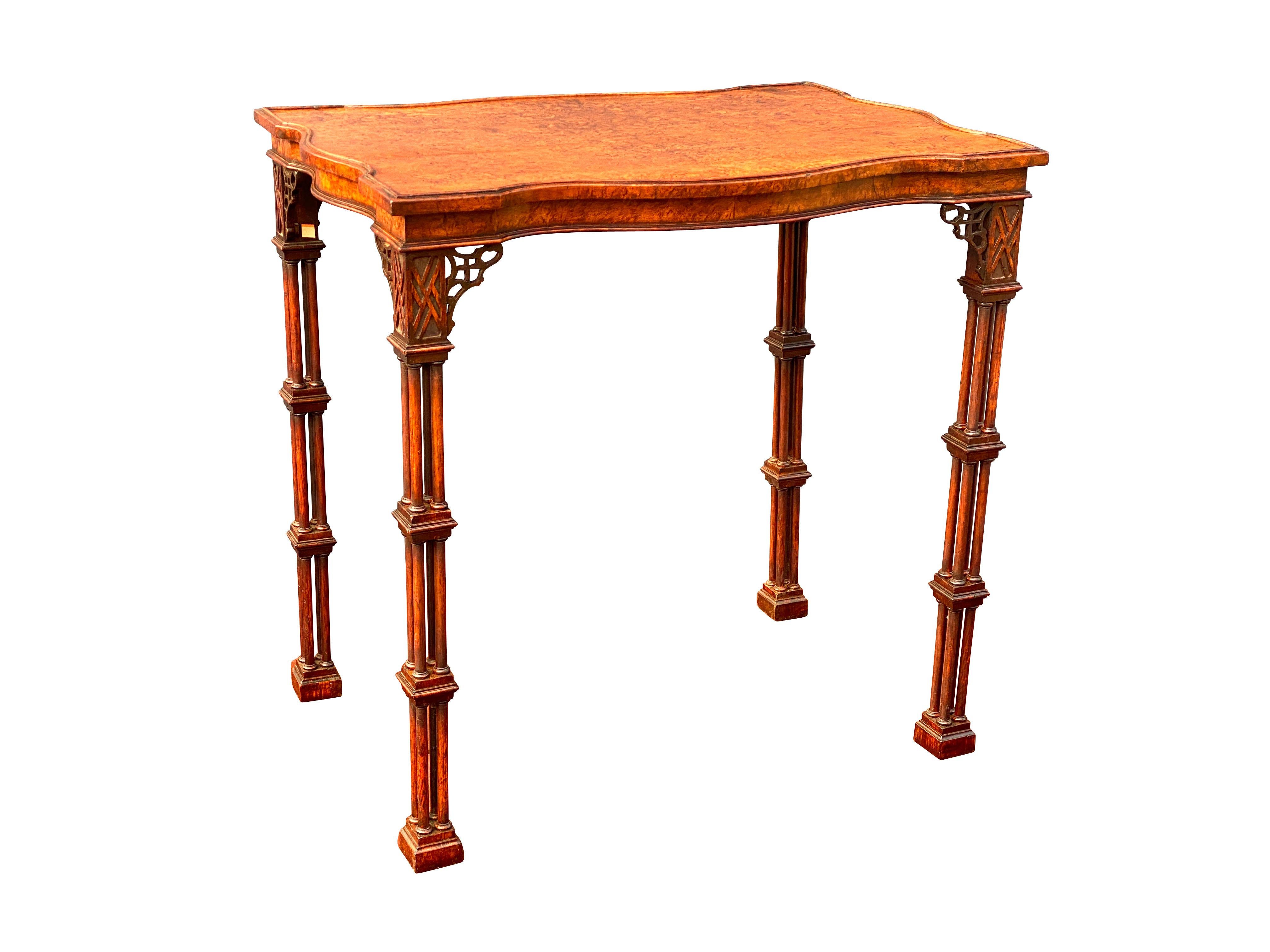Finely made with a wonderful burl veneer top of serpentine shape raised on cluster column legs headed by blind fretwork and fretwork spandrels. The conforming frieze with same burl walnut. Block feet. A very similar example made ca 1828 by Gillows