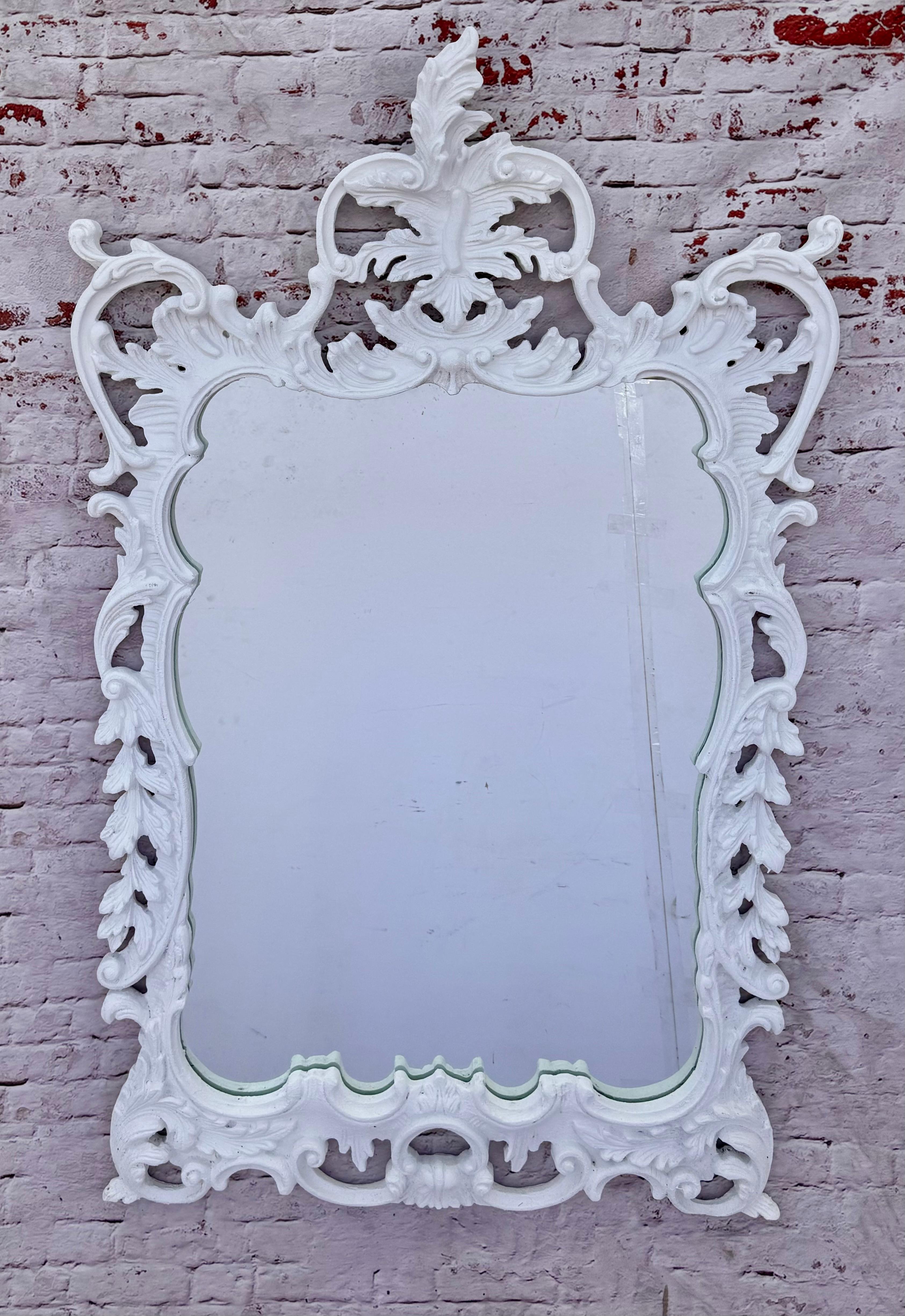 Raffinato specchio rococò in stile Giorgio III intagliato a mano e dipinto di bianco con foglie d'acanto, fogliame e volute su tutta la cornice. Il rococò è noto per le sue curve ornate e fluide e per l'abbondanza di dettagli decorativi. L'aspetto